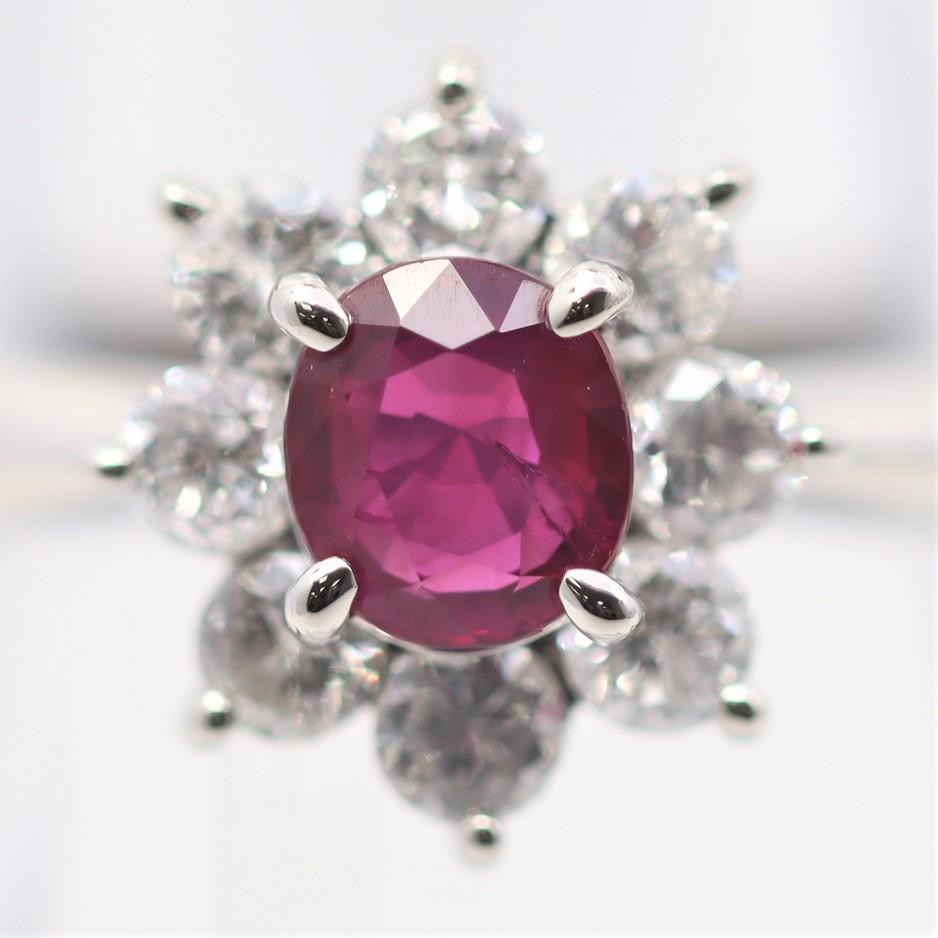 A smaller sized yet still very fine ruby ring. The ruby weighs 0.89 carats and has a rich vivid red color, very fine quality. It is accented by a halo of bright white round brilliant-cut diamonds weighing 0.75 carats. Hand-fabricated in platinum and