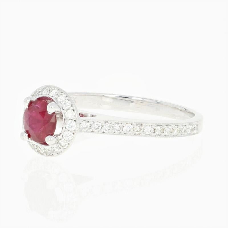 Let romance shine! Accented by ornate milgrain work and fashioned in a cathedral style, this gorgeous 14k white gold ring showcases a majestic ruby solitaire sweetly embraced by a sparkling diamond halo that is accompanied by radiant diamonds set