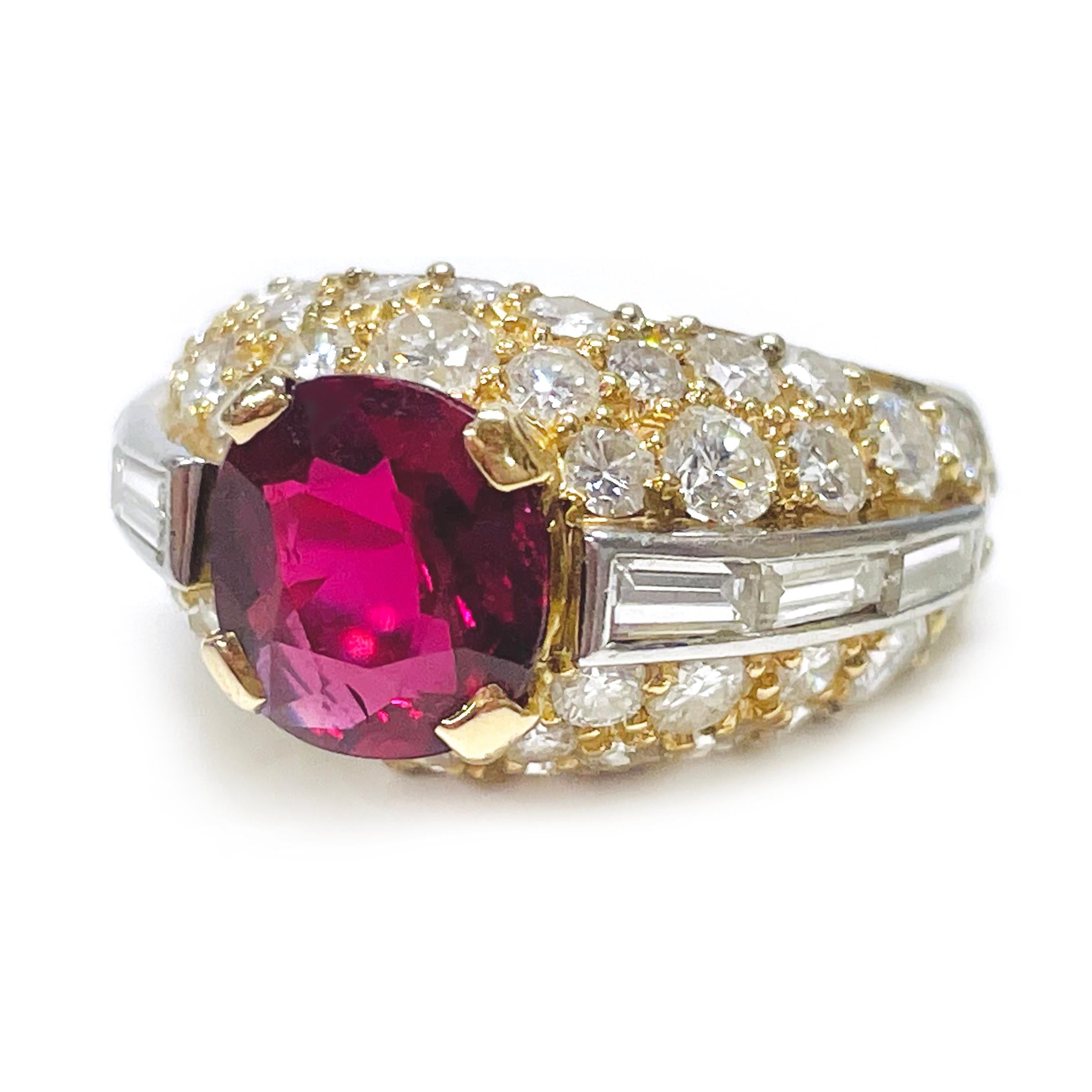 This 18 Karat Yellow Gold Ruby Diamond Hinged Ring is a stunning piece featuring a beautiful natural ruby set above a gallery of diamonds. The intricate design includes channel-set baguette diamonds and bead-set round diamonds, all set in a hinged