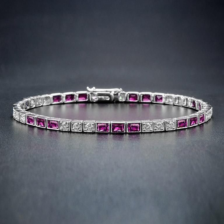 A gorgeous gemstone line bracelet from the Art Deco era! Crafted in 18K white gold, this fabulous piece features an alternating pattern comprised of sections of ruby and diamonds. The bracelet fastens at a push clasp seamlessly hidden within the