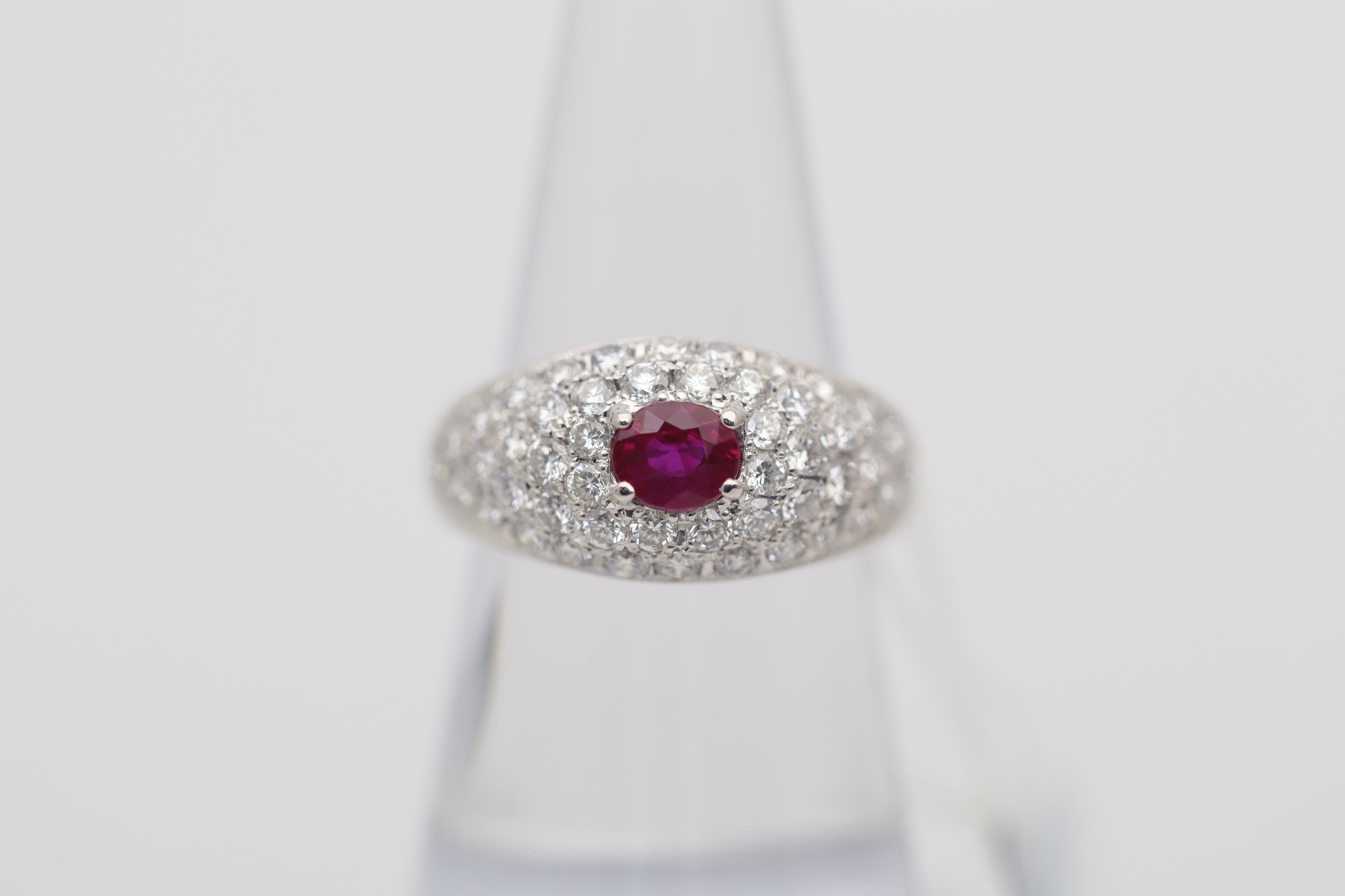 A classy ring featuring a gem of a ruby weighing 0.67 carats with a rich vivid red color. It is complemented by 1.45 carats of bright white pave-set diamonds surrounding the ruby and adding brilliant and sparkle to the piece. Hand-fabricated in
