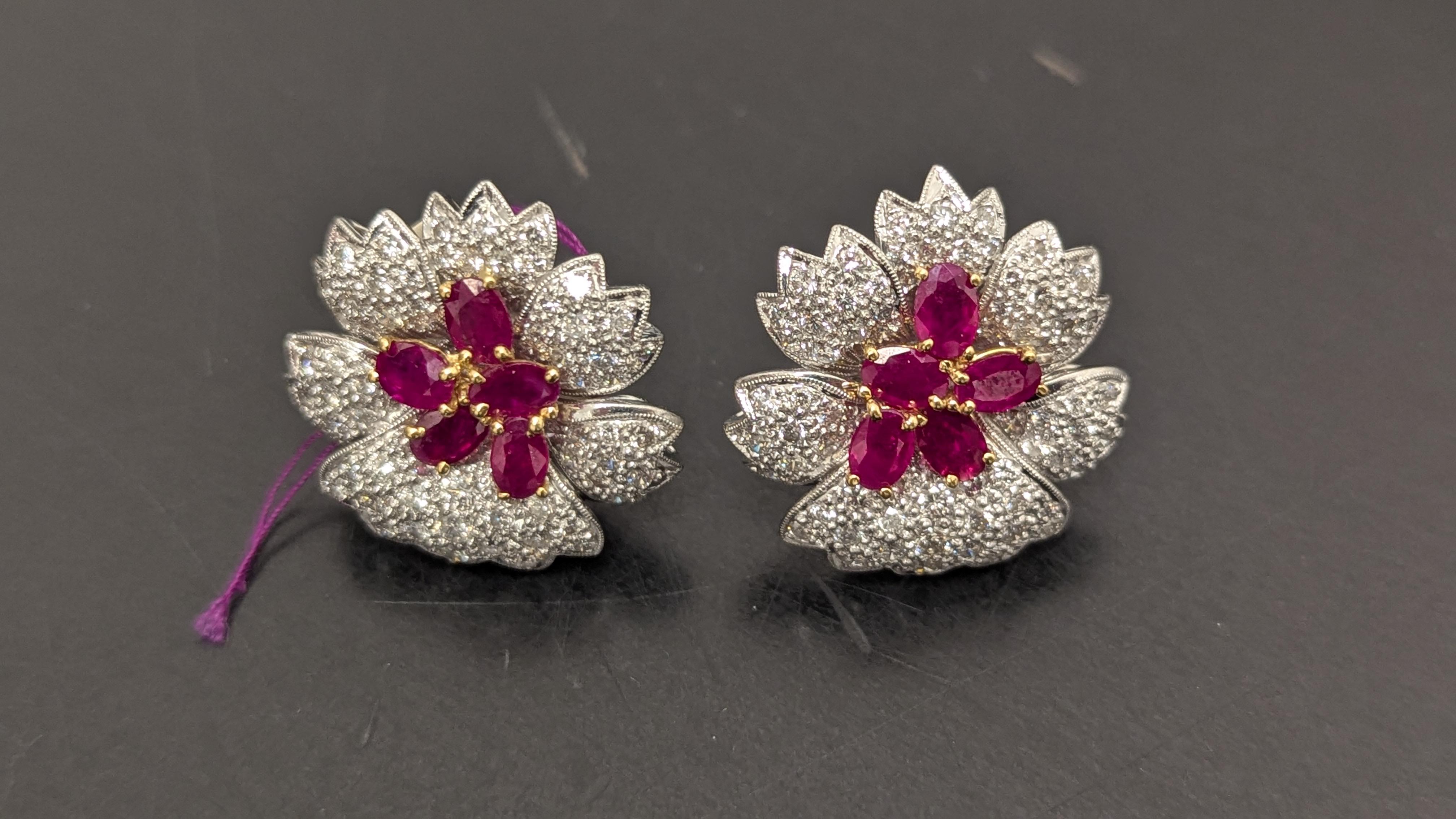 Five carats of diamonds, clustered together to form flower petals, encircle 10 rubies, which weigh approximately 7-8cts and are believed to have originated in Burma, are set in platinum to make for a pair of Flower Earrings.