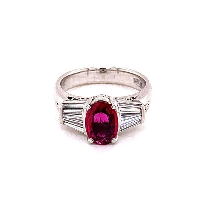 A superb hand-fabricated ring featuring a 1.07 carat oval shaped ruby. The ruby is eye clean with no visible inclusions and has a vivid red color and strong brilliance. It is accented with baguette cut diamonds on its side, all set in platinum.