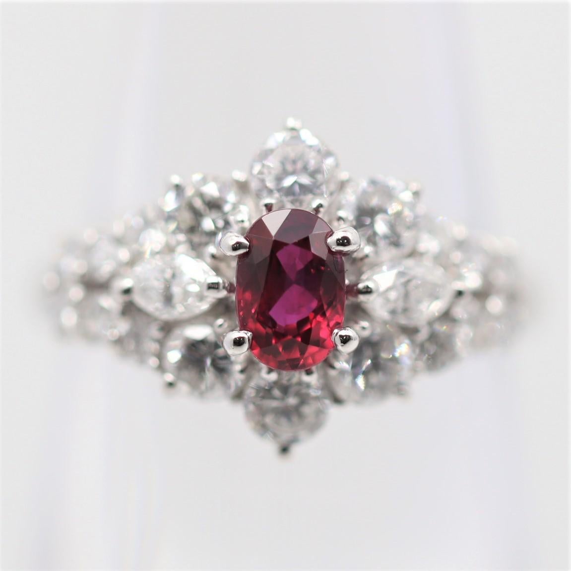 An elegant and chic ruby & diamond ring. It features a 0.64 carat oval shape ruby with a luscious vivid red gem color that will rival any other stone. It is accented by 1.36 carats of diamonds set around the ruby in a sunburst style. Hand-fabricated