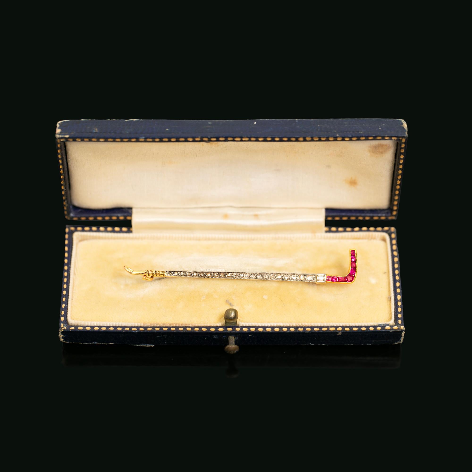 A beautiful pre 1917, Russian made riding crop brooch set with rose cut diamonds and synthetic rubies. Fitted and secured with a pin and hook catch. Hallmarked and stamped with Russian Zolotnik mark 72. Presented in the jewellers original