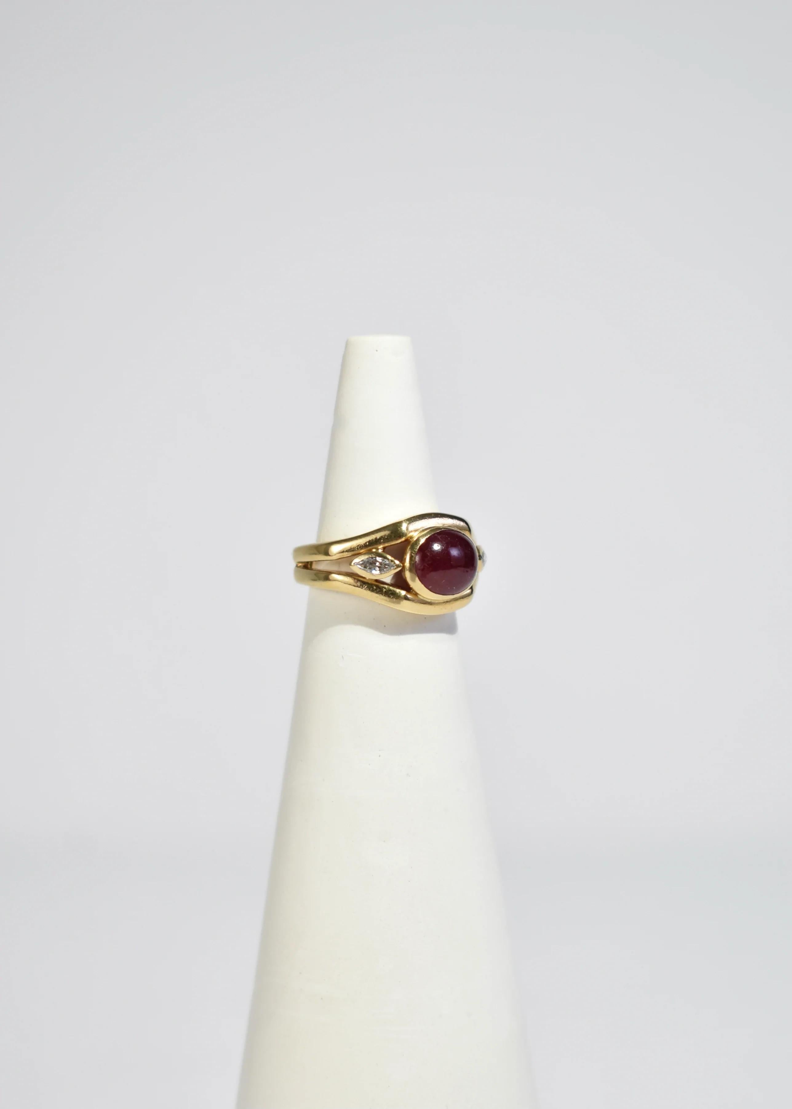 Stunning vintage gold ring featuring polished ruby cabochon and marquise cut diamonds. Stamped 18k.

Material: 18k gold, ruby, diamond.

We recommend storing in a dry place and periodic polishing with a cloth.