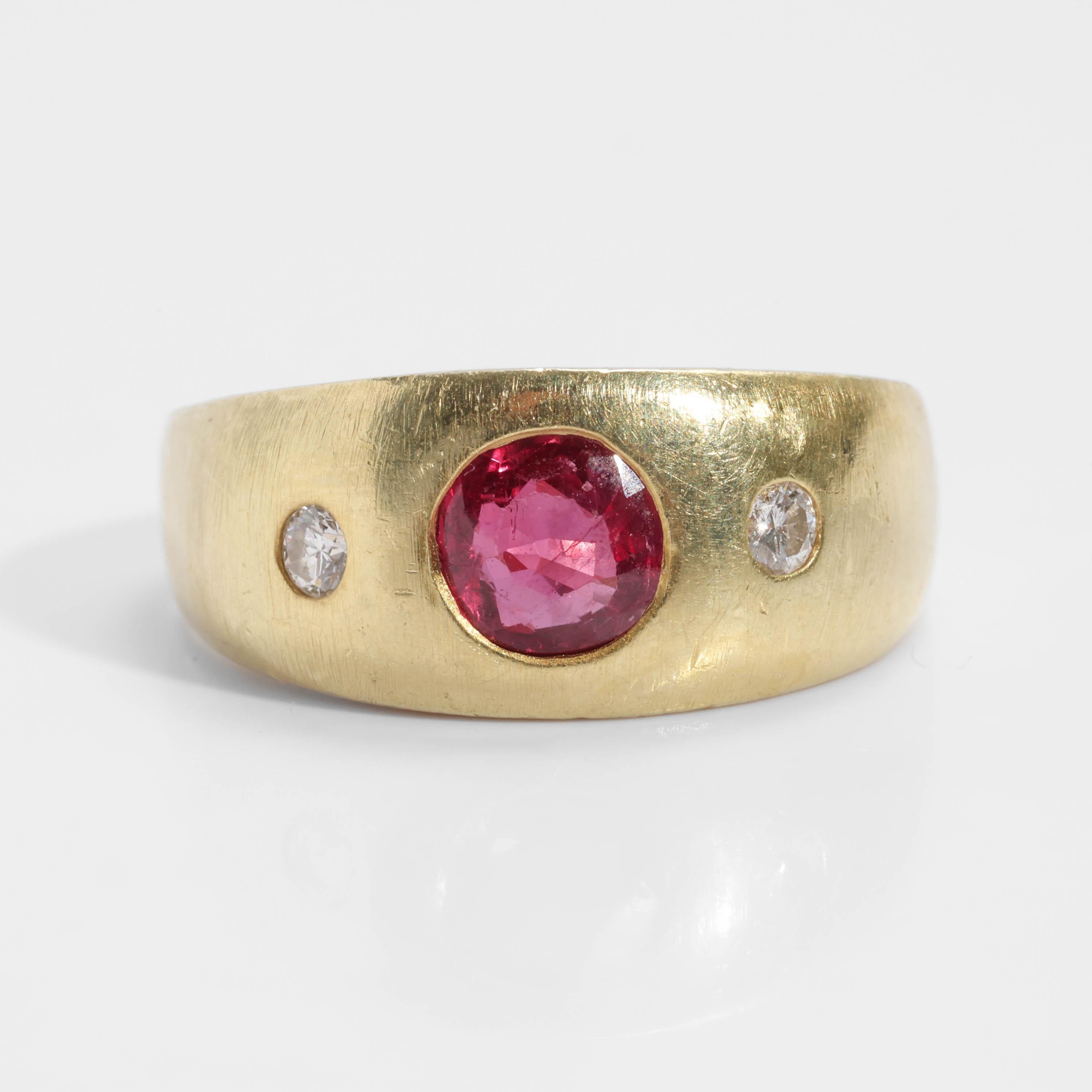 What a timeless and classic men's ruby and diamond ring! Dating to the 1950s, this sleek, buttery 14K yellow gold ring features a 5.7mm round faceted ruby that weighs .55 carats. The gorgeous red color is bright and open. On either side of the ruby,