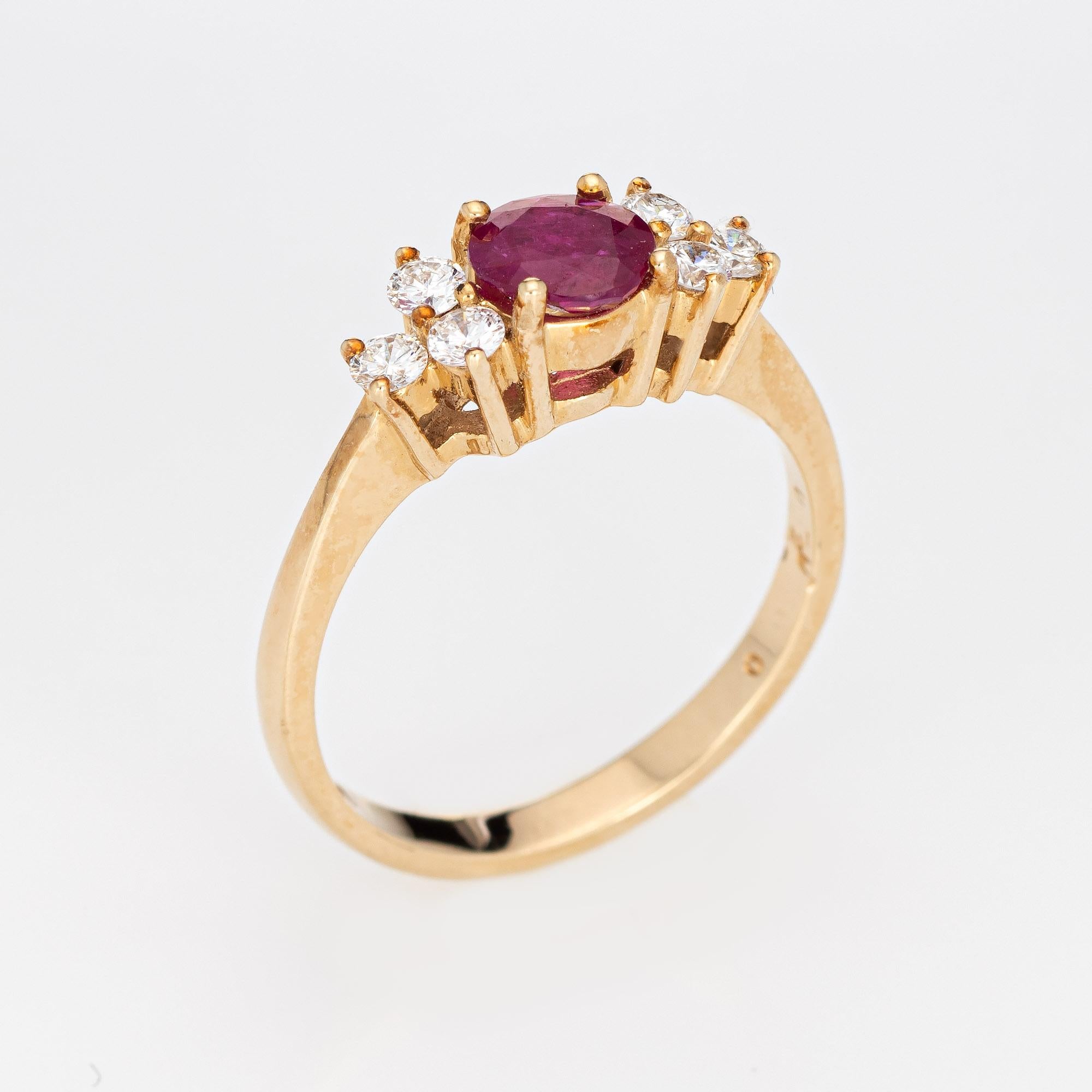 Stylish vintage ruby & diamond ring (circa 1980s to 1990s) crafted in 14 karat yellow gold. 

Faceted round cut natural ruby is estimated at 0.85 carats, accented with six estimated 0.05 carat round brilliant cut diamonds. The total diamond weight