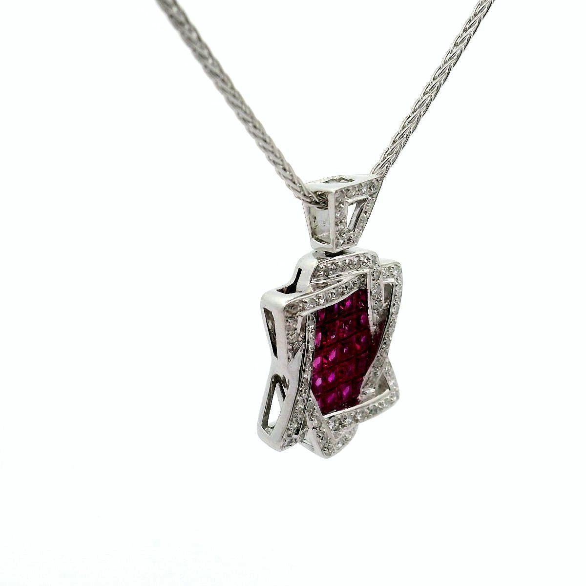 Un'accattivante collana con ciondolo a forma di Stella di David con al centro una serie di rubini incastonati invisibili del peso di 1,98 carati, dal forte colore rosso vivo. Il rubino è elegantemente incorniciato da diamanti bianchi tondi e