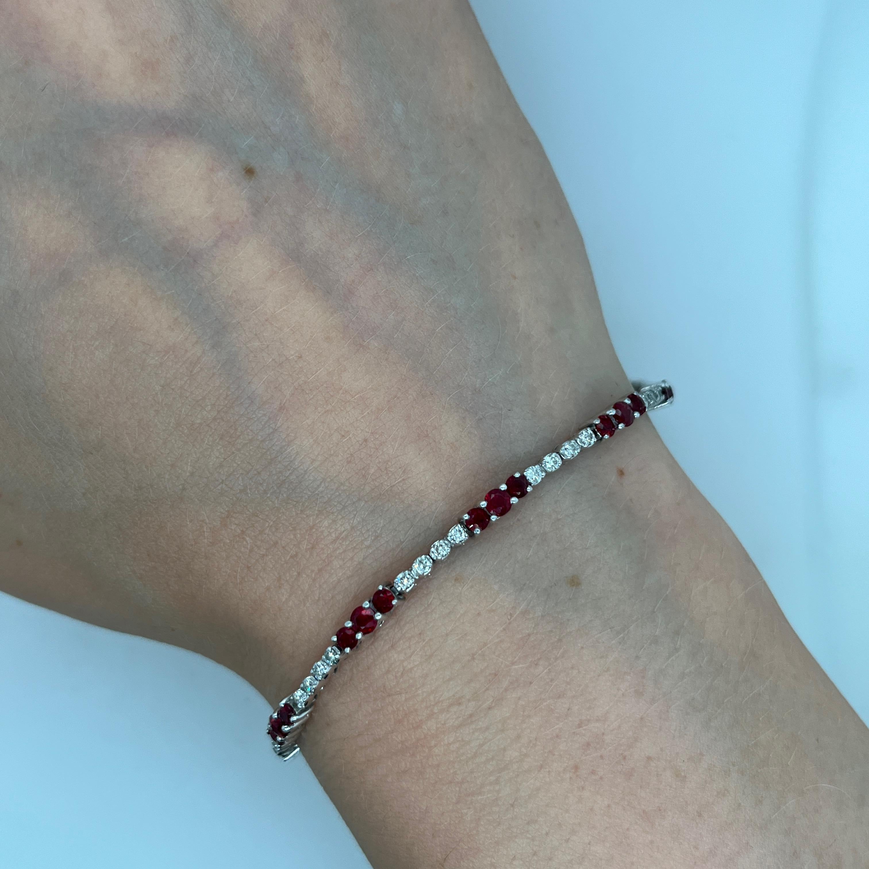 Atemporal y elegante pulsera tenis de oro blanco de 18 quilates, engastada con 0,70 quilates de diamantes redondos naturales de talla brillante y aproximadamente 2,0 quilates de rubíes redondos. 
Este diseño clásico ofrece brillo y sofisticación