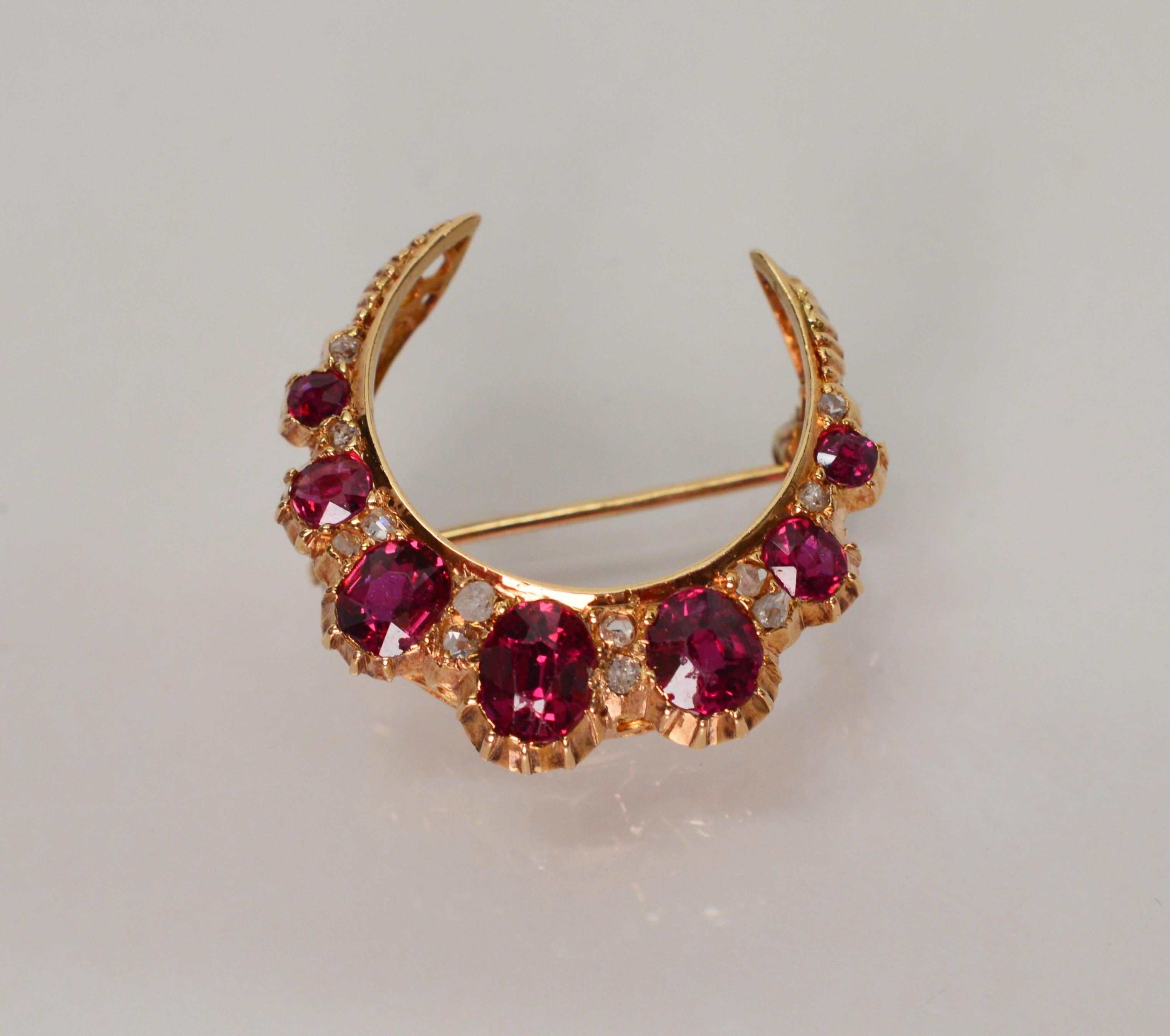 This classic American piece, in fourteen karat yellow gold, presents remarkably vivid natural ruby gemstones with a total weight of 1.0 carat highlighted by twelve rose cut diamonds with a total weight of .06 carats. The brooch pin measures 7/8 inch