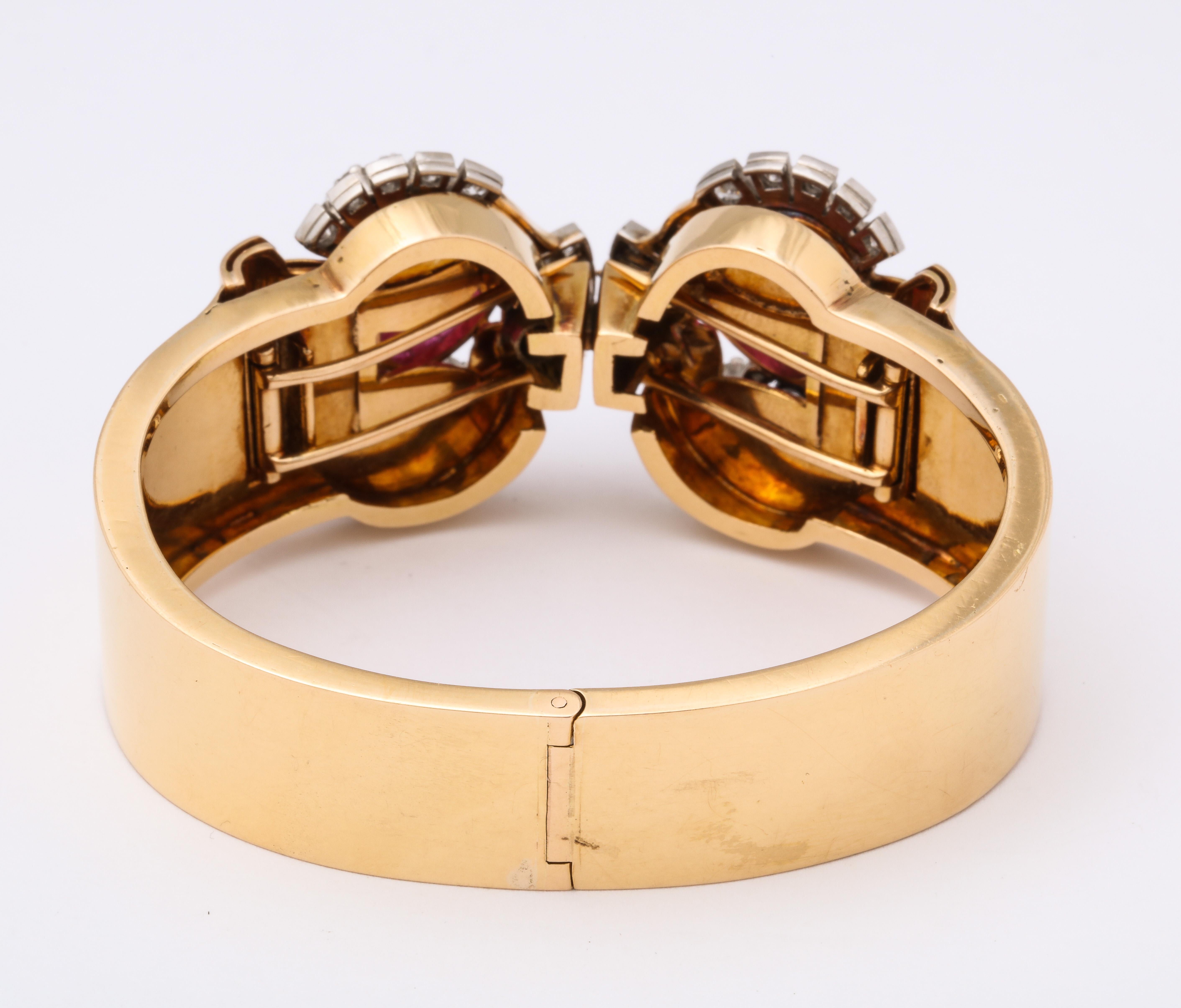 A retro hinged bangle bracelet, circa 1970, in 18k Yellow Gold, unmarked but tested.  84 full cut diamonds weigh approximately 2 carats.  Two carved ruby leaves weighing approximately 1.5 carats. The two fur clips come off to be worn as pins.  For a