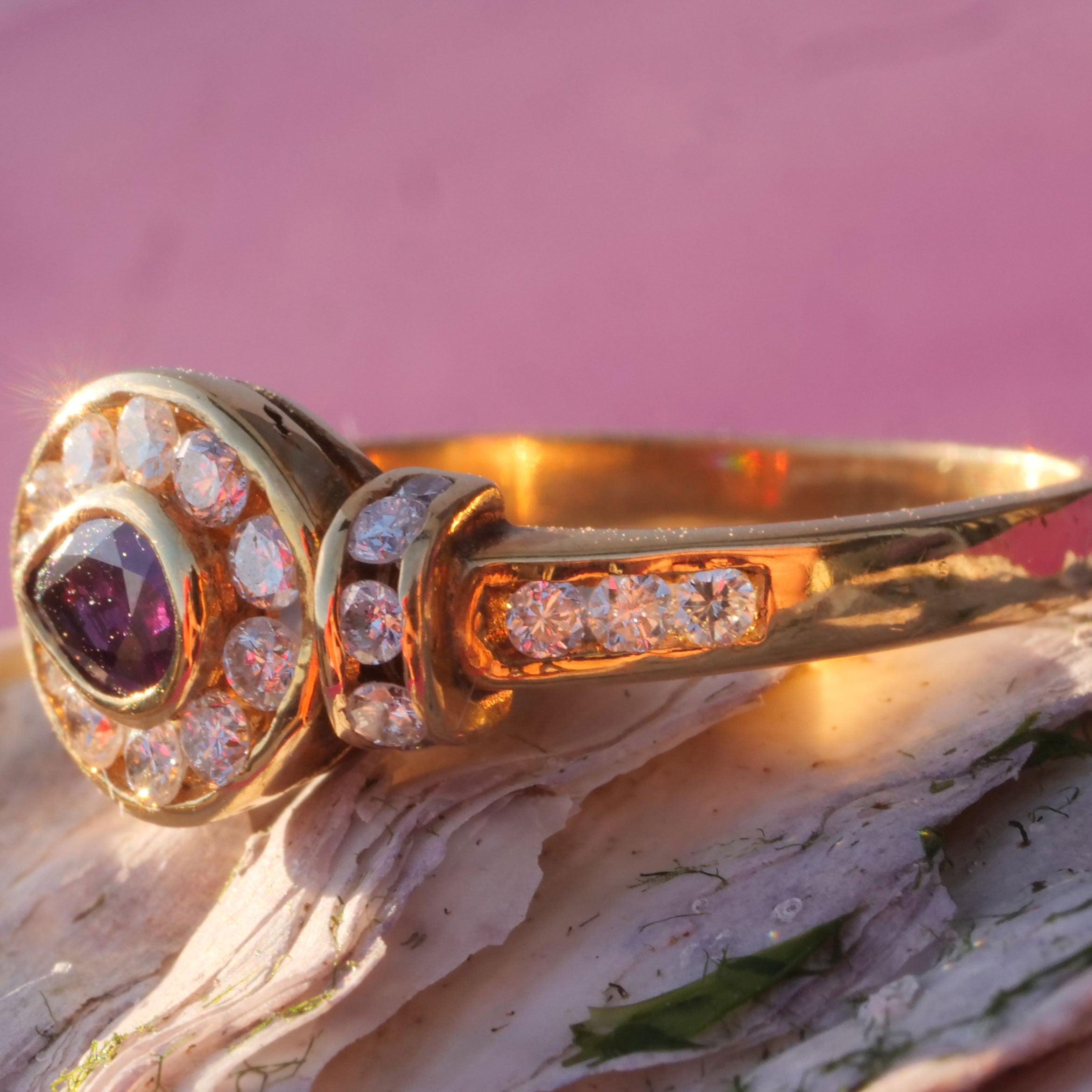 dieser Ring wird an Ihren Händen sehr hübsch aussehen, ein rosaroter Rubin von 0,15 ct umgeben von Vollschliffdiamanten ca. 0,25 ct, W (weiß) / SI (kleiner Einschluss), 18 kt Gelbgold, Brillantbesatz auch auf den Ringschultern, schöne