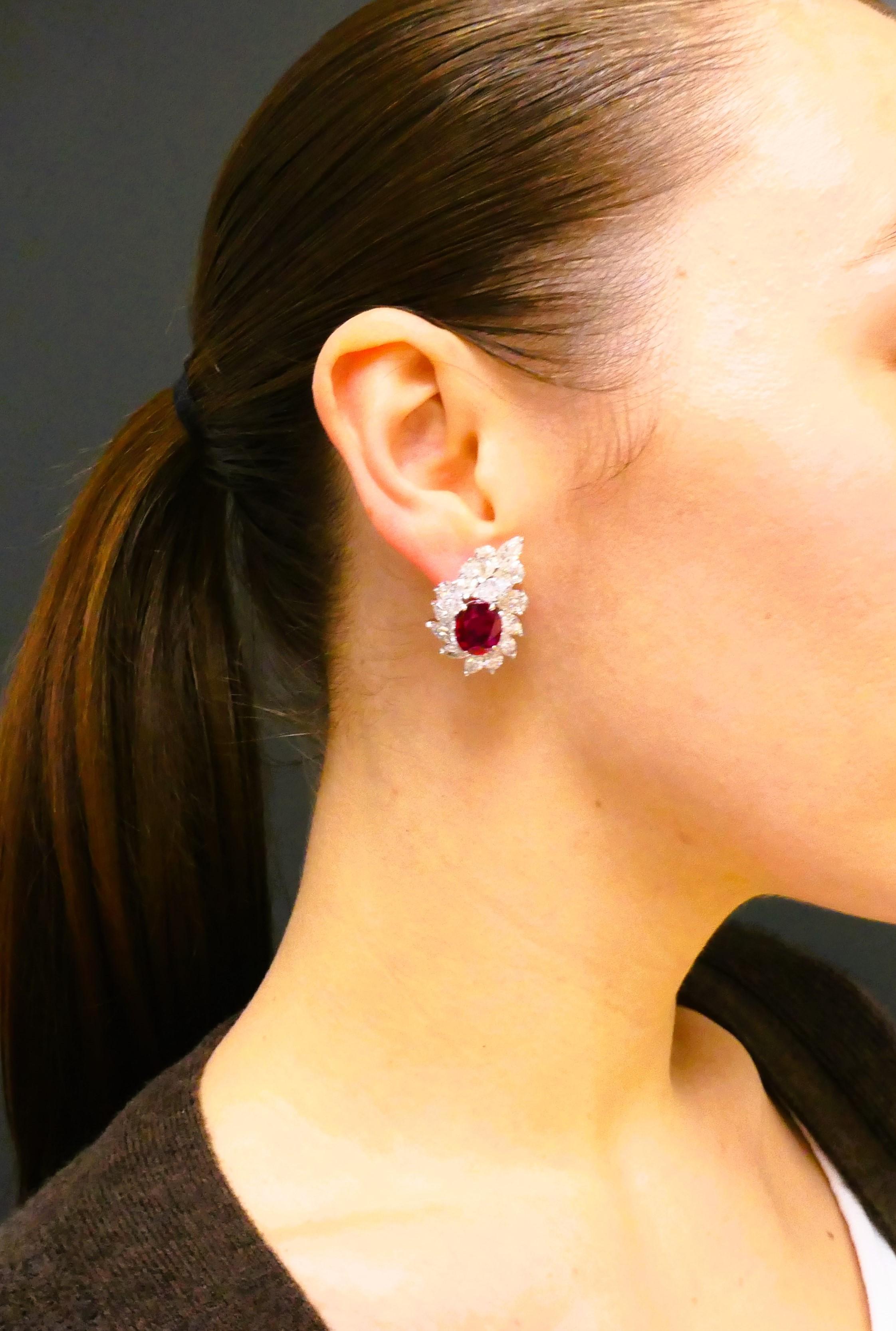 A pair of ruby earrings with cluster diamond design, made of 18k gold.
A truly gorgeous and refined modern creation, these diamond earrings feature two vivid red Mozambique rubies. Each gemstone is certified as natural Mozambique ruby with no