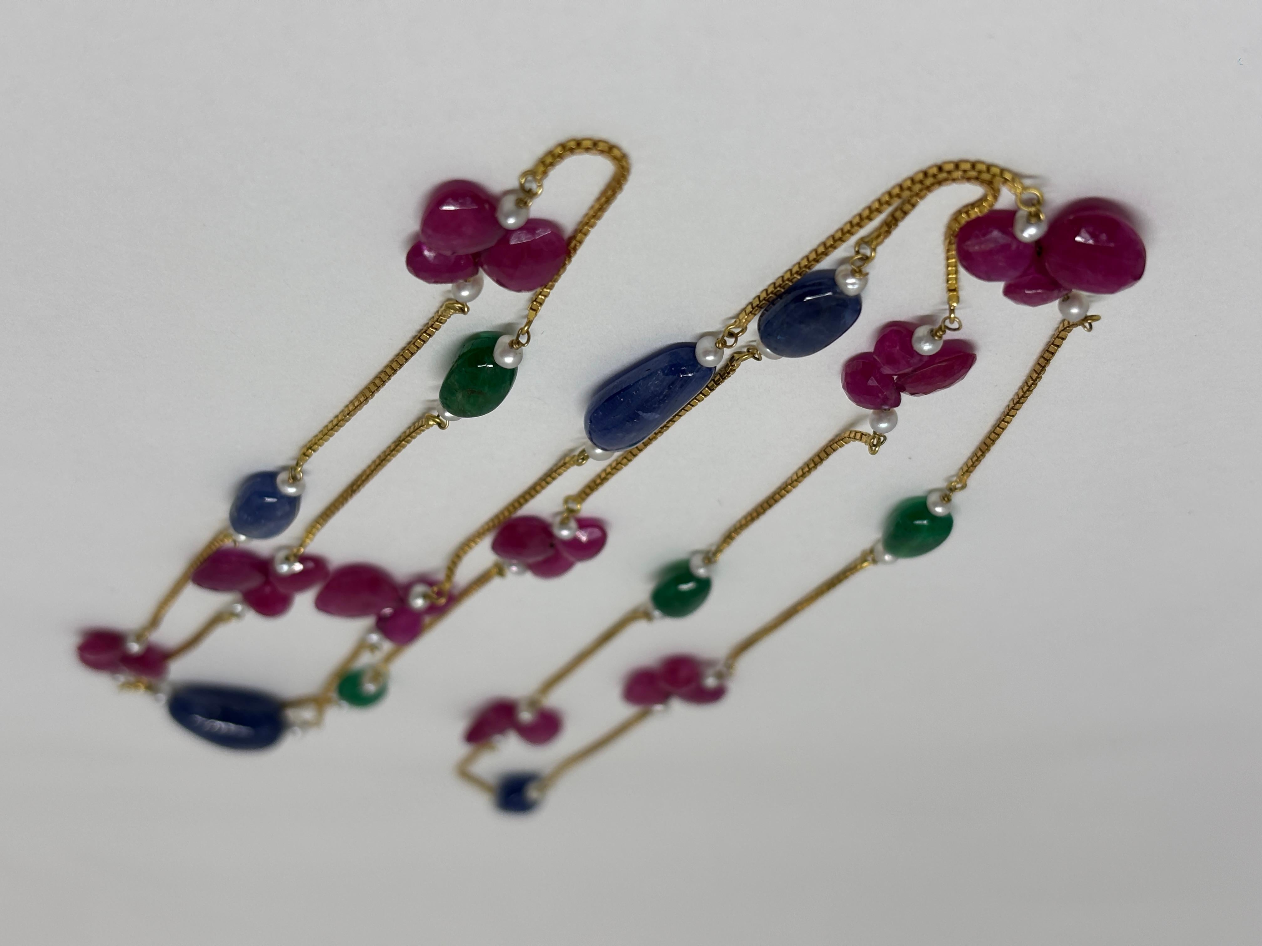 Dieses exquisite Collier besticht durch eine Kombination aus erhitzten Rubinen aus Mosambik, unbehandelten Saphiren aus Birma und leuchtenden Smaragden aus Sambia. 

Das 39-Zoll-Design ist mit einer zarten Goldkette geschmückt, die den satten Farben