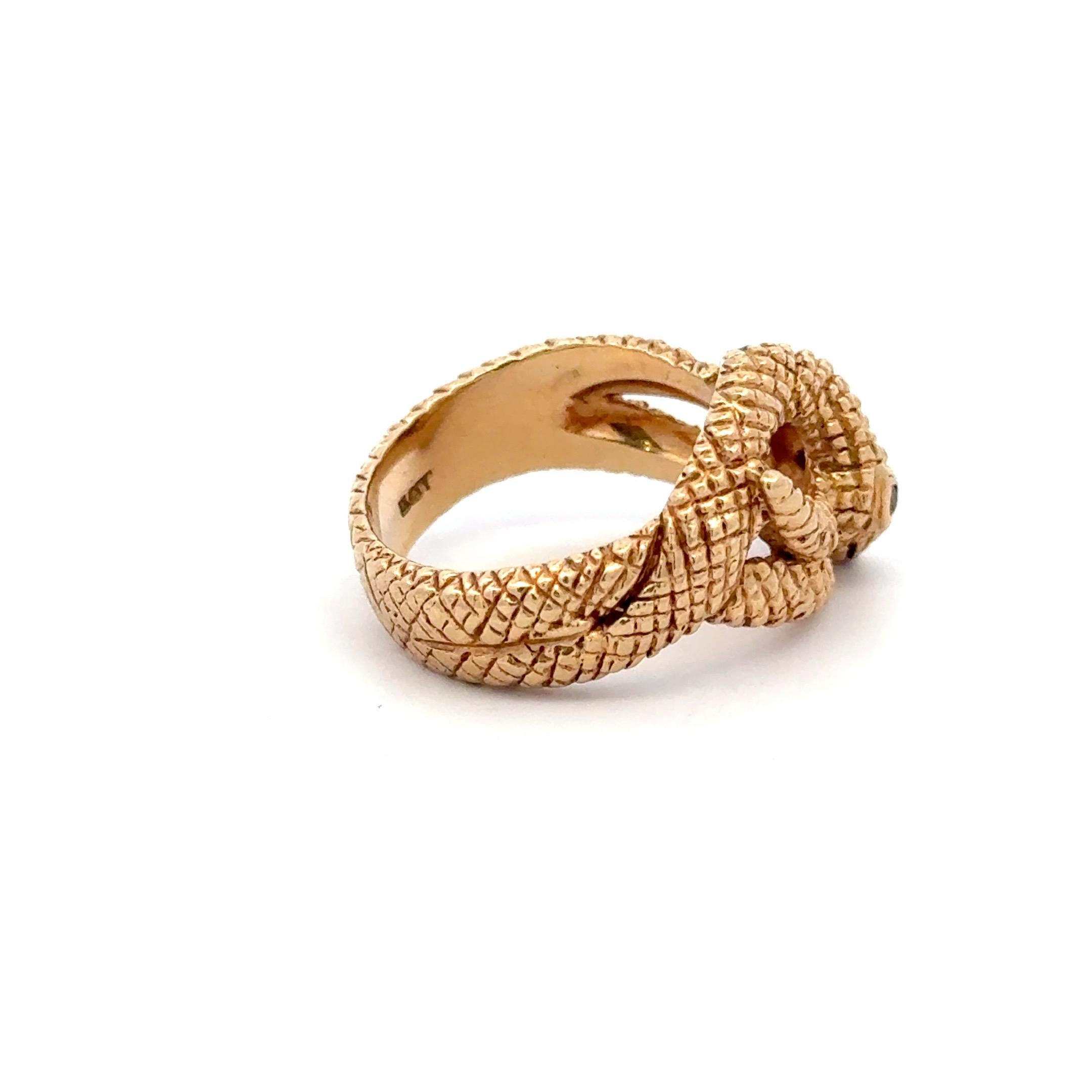 14 Karat yellow gold band ring featuring a snake motif with two ruby eyes weighing 11.6 grams, size 7.5. 
