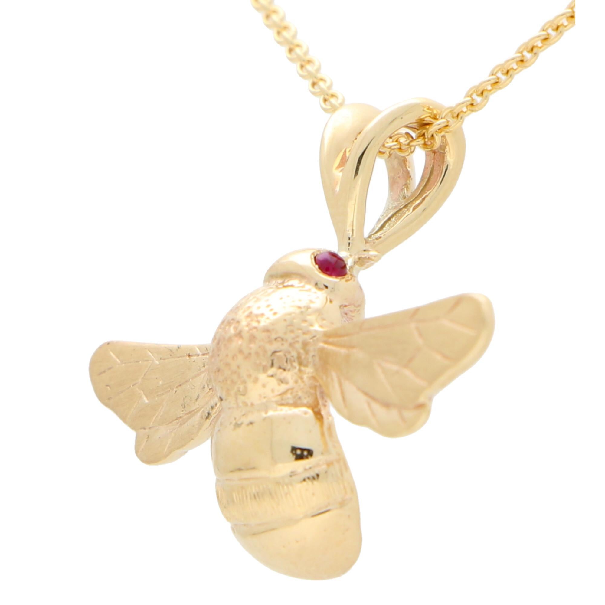 A beautiful cabochon ruby eyed bee pendant necklace set is 9k yellow gold.

The pendant depicts a lovely naturalistic bumble bee with delicate detailing on the wings and body. The bee is set with two vibrant red cabochon ruby eyes which add a