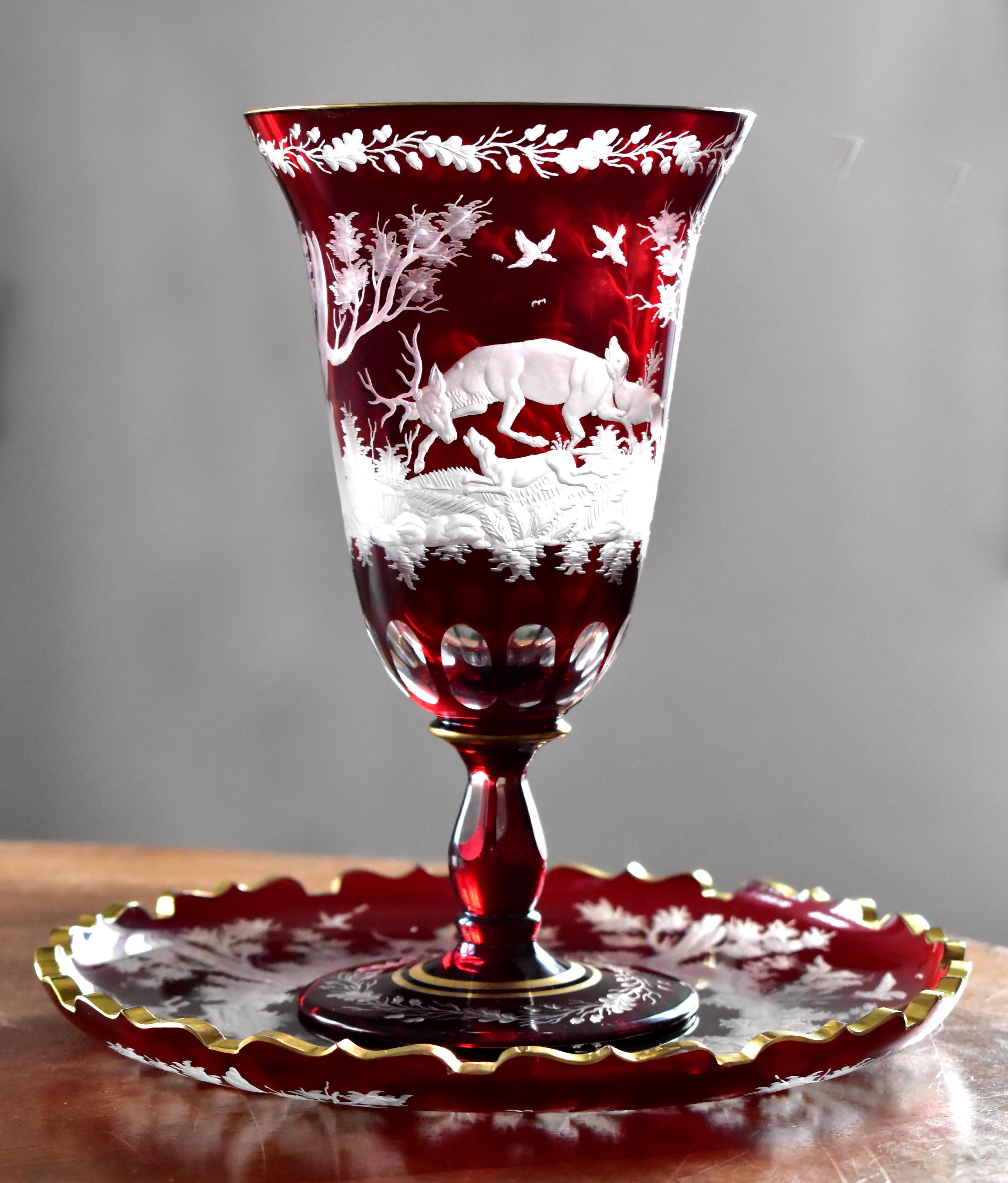 A beautiful goblet with a ruby lazure, goblet partly cut with a beautiful engraving of forest animals.In particular, the plate has an interesting cut edge that is gilded. The goblet is also complemented by gilding. Both the engraving and the shape