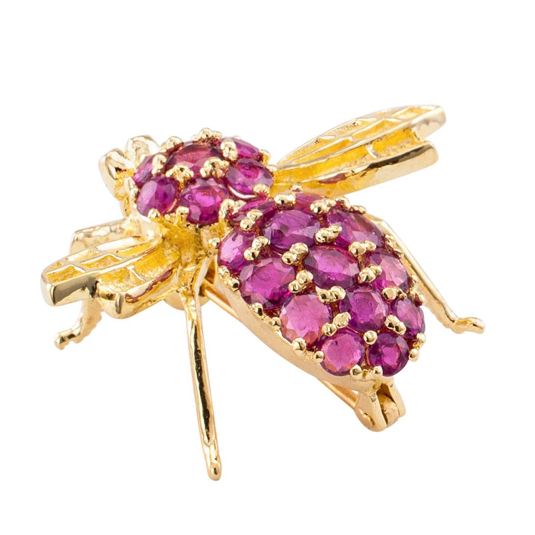 Ruby and gold bee brooch circa 1980. Designed with spread-out gold wings, the body pavé-set with round rubies, mounted in 14-karat yellow gold. Very pristine condition consistent with age and wear. What is it we like about it? It is a pretty ruby