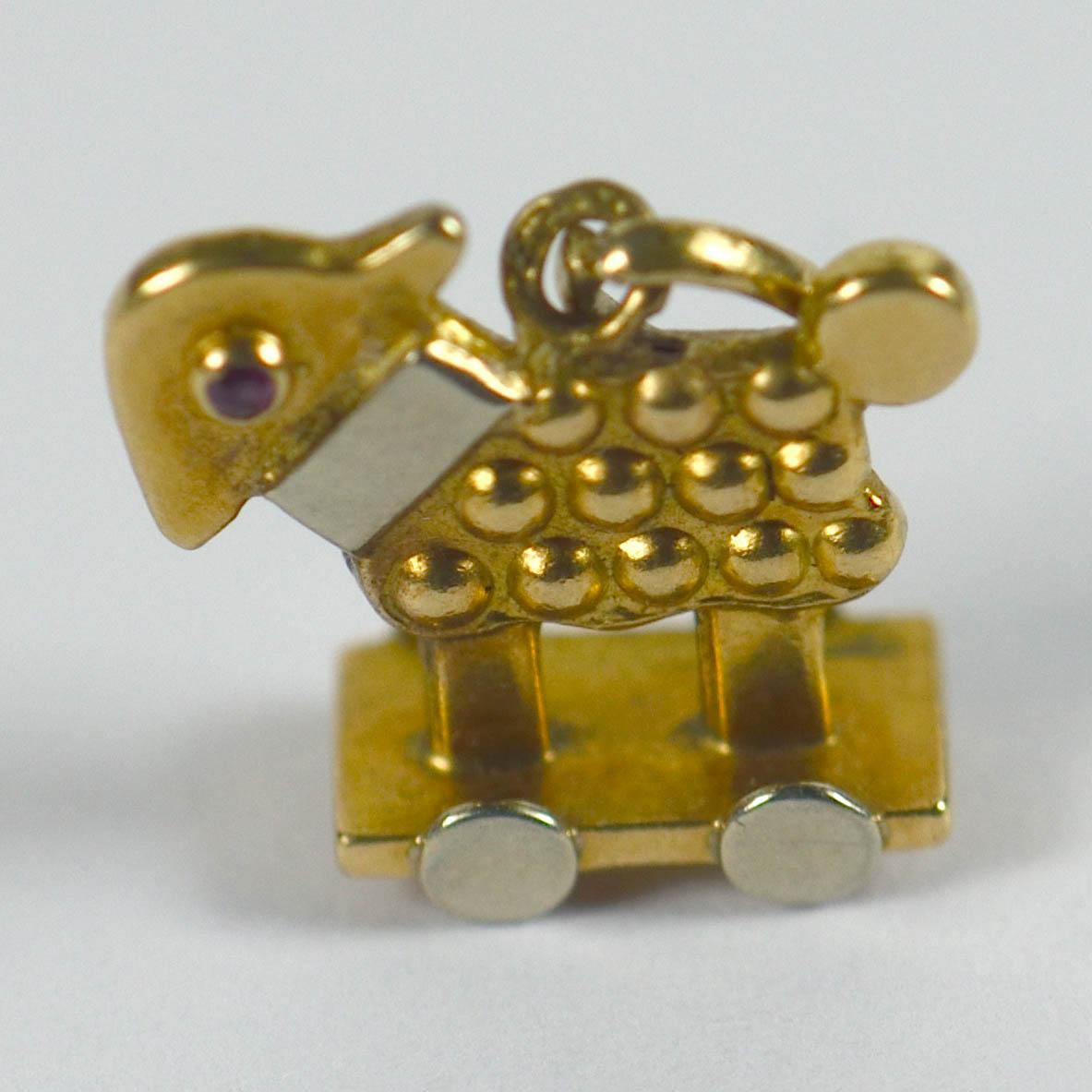 An adorable toy sheep charm in white and yellow 18 karat gold with ruby eyes. The charm is double sided, and was probably made by Cartier as part of its nursery charm set. An ideal gift to commemorate a new addition to the family! Stamped with