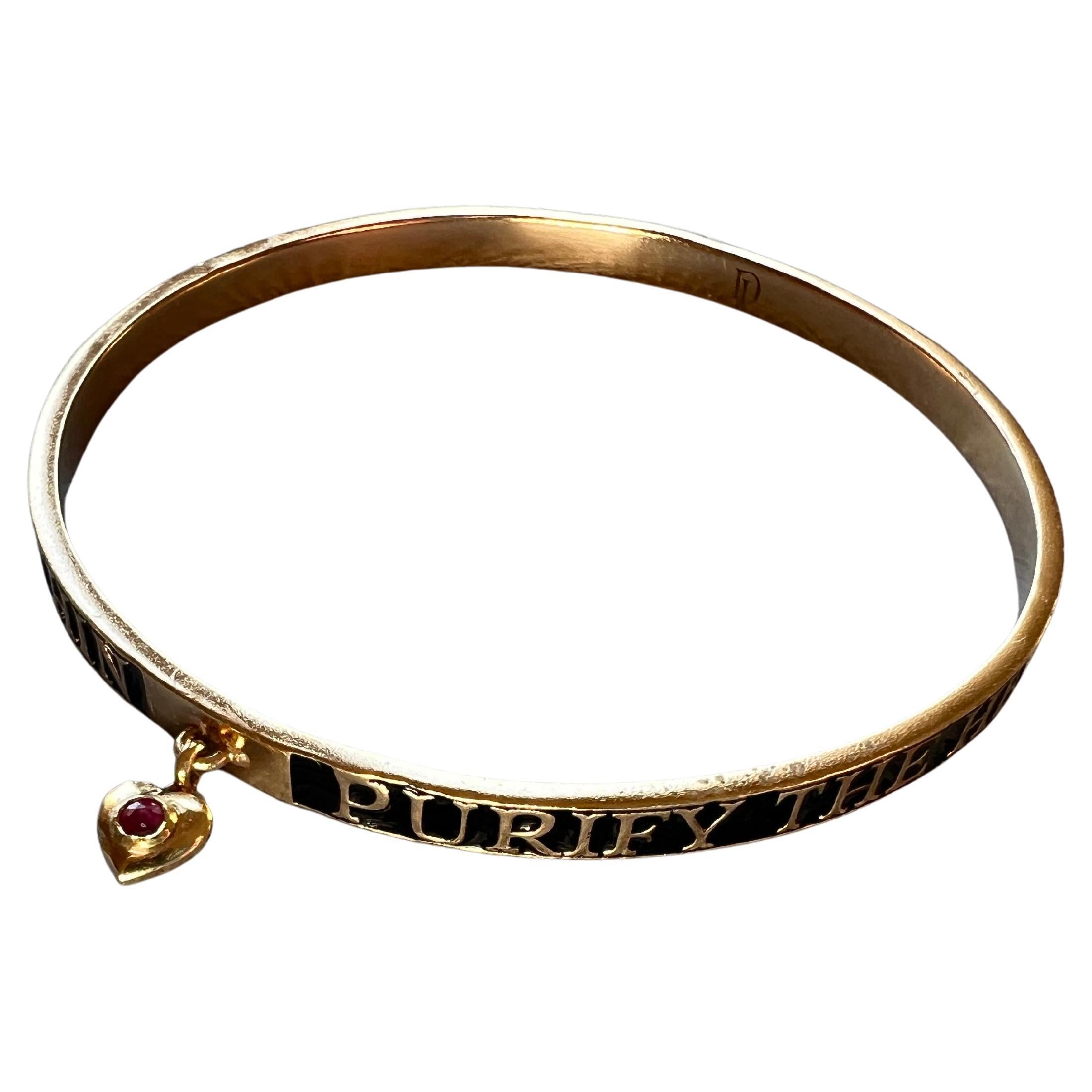 Ruby Heart Bangle Bracelet Spiritual Black Enamel

14k Gold plate with handpainted Black Enamel and a dangling heart set with a ruby.

The text on the bracelet say: Purify your heart and the infinite light will dwell within.

Designer J