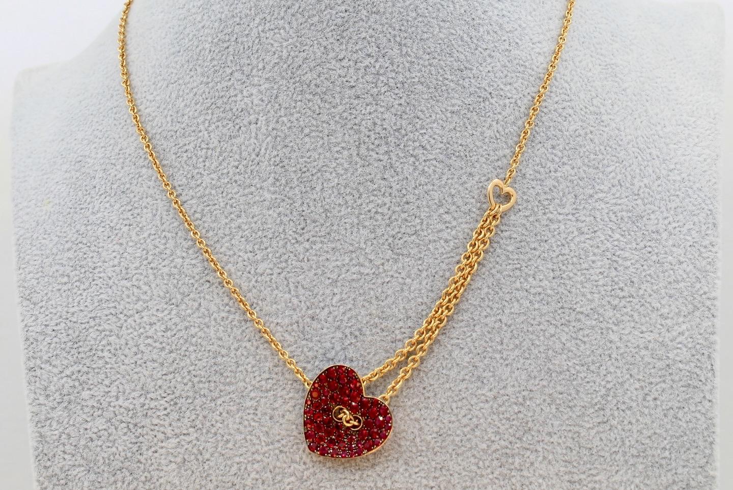 Una collana a tema cuore unica nel suo genere! Questo modello mette sicuramente il rosso nel cuore con 2 carati di rubini incastonati in oro rosa 18 carati. Il tema continua con un anello a forma di cuore sul lato destro (sinistra di chi lo indossa)