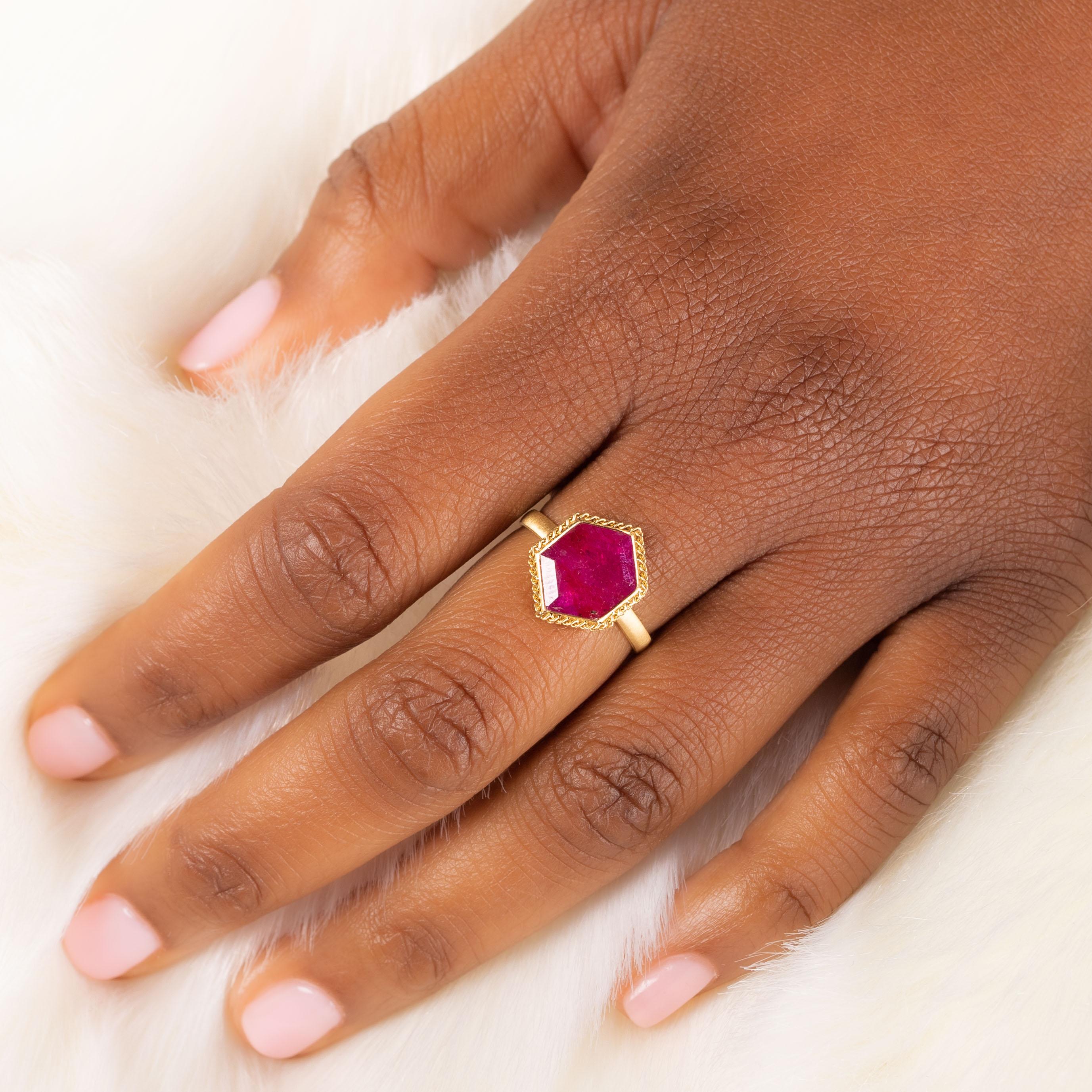 This Ruby ring looks like it came straight out of a pirate’s treasure chest with its hexagonal shape and faceted surface that catches the light and glistens. This gemstone is set in a handmade, 18k gold bezel with braided detail and granulated
