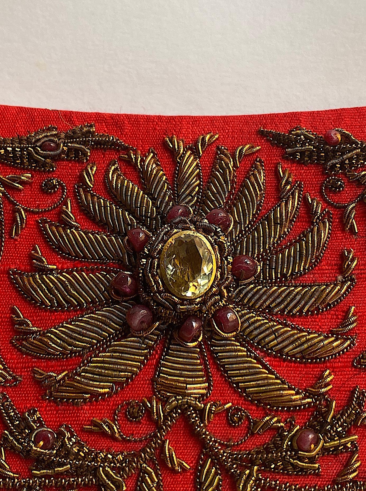 A beautiful and intricate hand embroidered evening bag from India. The use of gold and silver thread and precious jewels in embroidery is known as Zardozi and was once used to embellish the attire of the Kings and the royals in India. Red silk