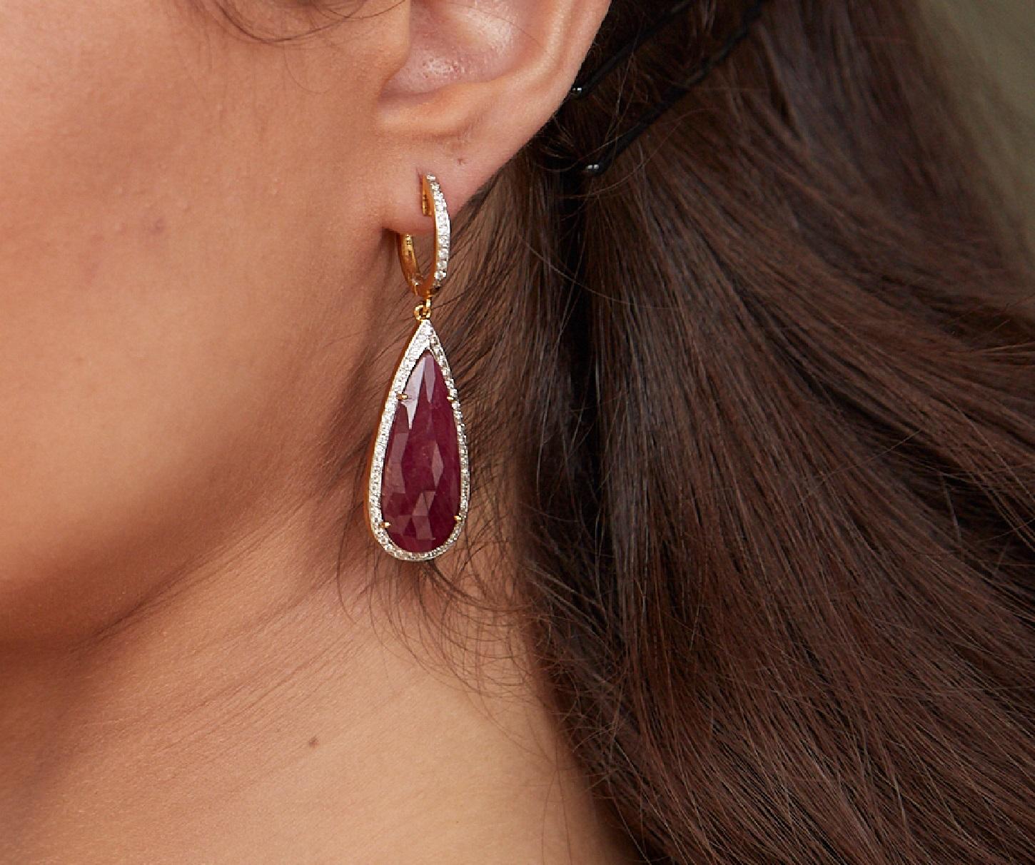 Tresor Diamond Earring features 1.46 cts diamond and 16.11 cts Ruby in 18k yellow gold. The Earring are an ode to the luxurious yet classic beauty with sparkly diamonds. Their contemporary and modern design makes them versatile in their use. The