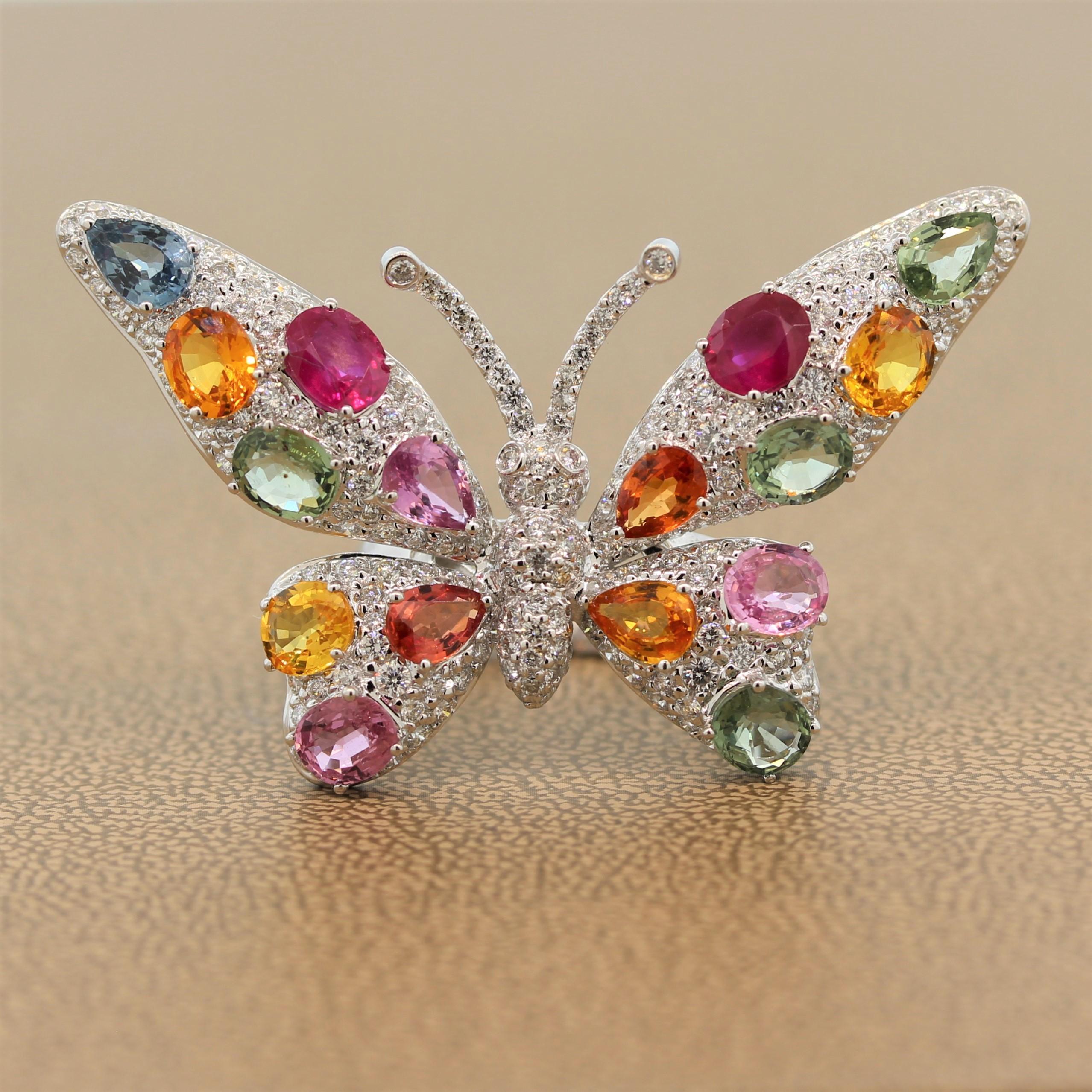 This butterfly is ready to take flight! A splendid ring featuring 8.56 carats of rubies and multi-colored fancy sapphires. The oval and pear cut gemstones cover the wings of the 18K white gold ring with 1.91 carats of shimmering diamonds covering