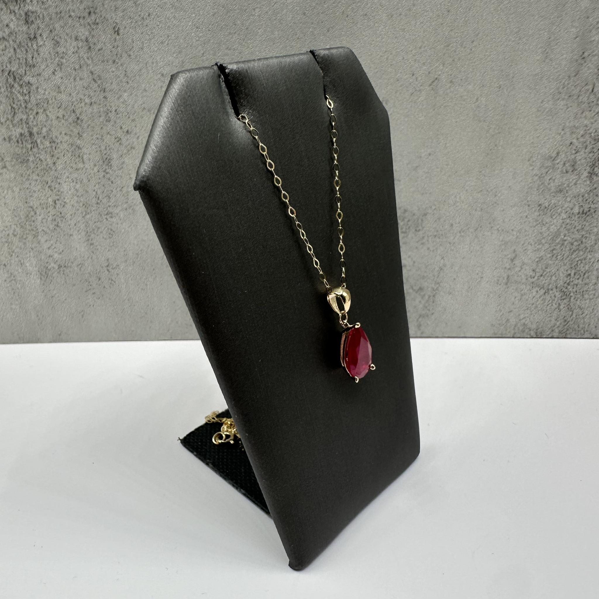 Cet élégant collier de rubis en or jaune 14kt est orné d'un rubis poire de 1,97 carat qui rayonne d'un rouge profond et d'une beauté intemporelle. La pierre précieuse est complétée par l'éclat chaud et poli de l'or jaune, créant ainsi une pièce