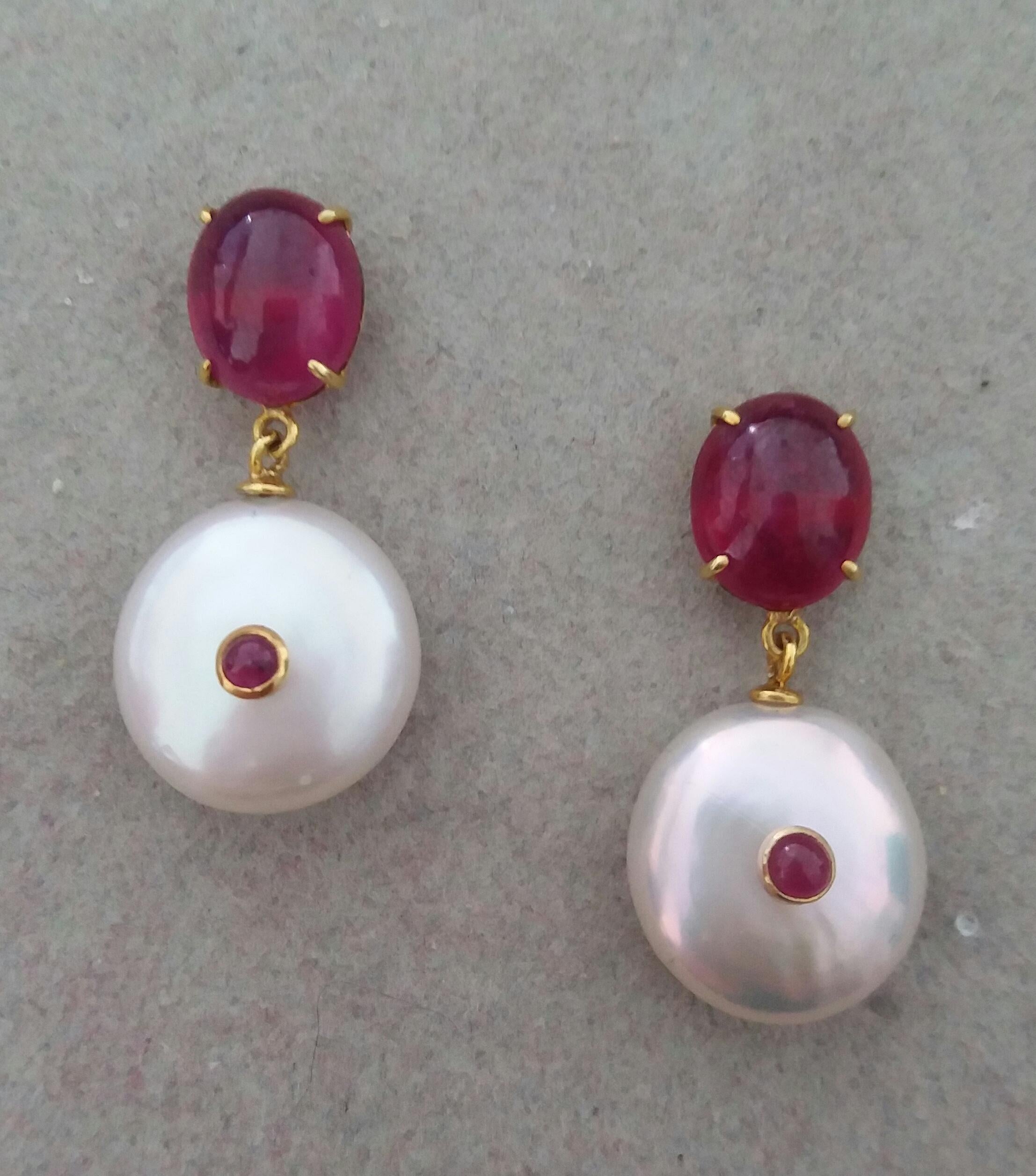 Simple and elegant earrings consisting of an upper part with  oval shape Ruby cabs of 9 mm x 10 mm set  in 14 Kt yellow gold, at the bottom 2 nice  button shape white color and high luster Baroque Pearls measuring about 15 mm in diameter with 2