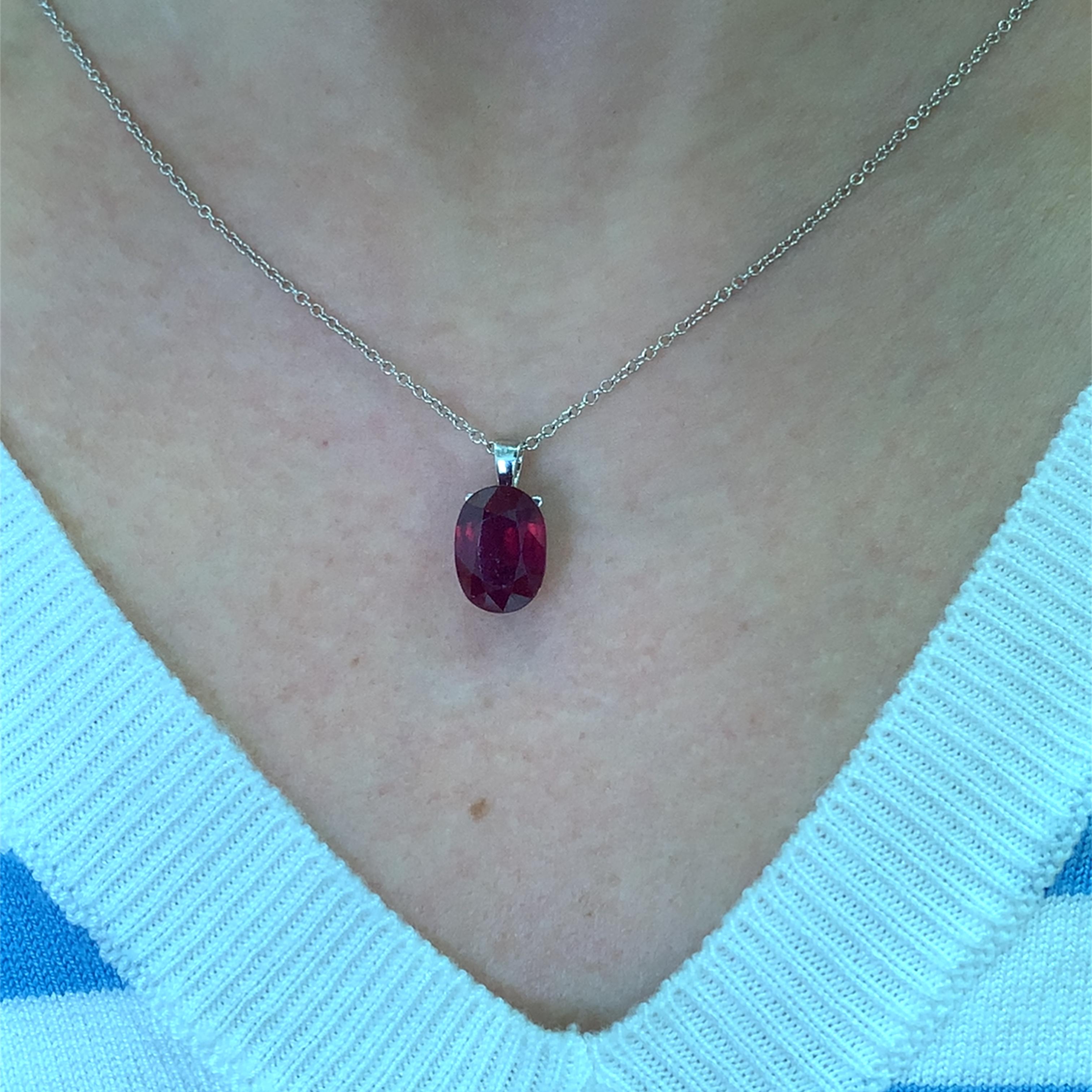 Questa splendida collana con ciondolo a forma di rubino ovale grande 5,10ct, che misura circa 13/9mm, presenta un rubino ovale splendidamente tagliato, elegantemente sospeso da un delicato pendente in oro bianco 18k.  catena. La ricca tonalità rossa