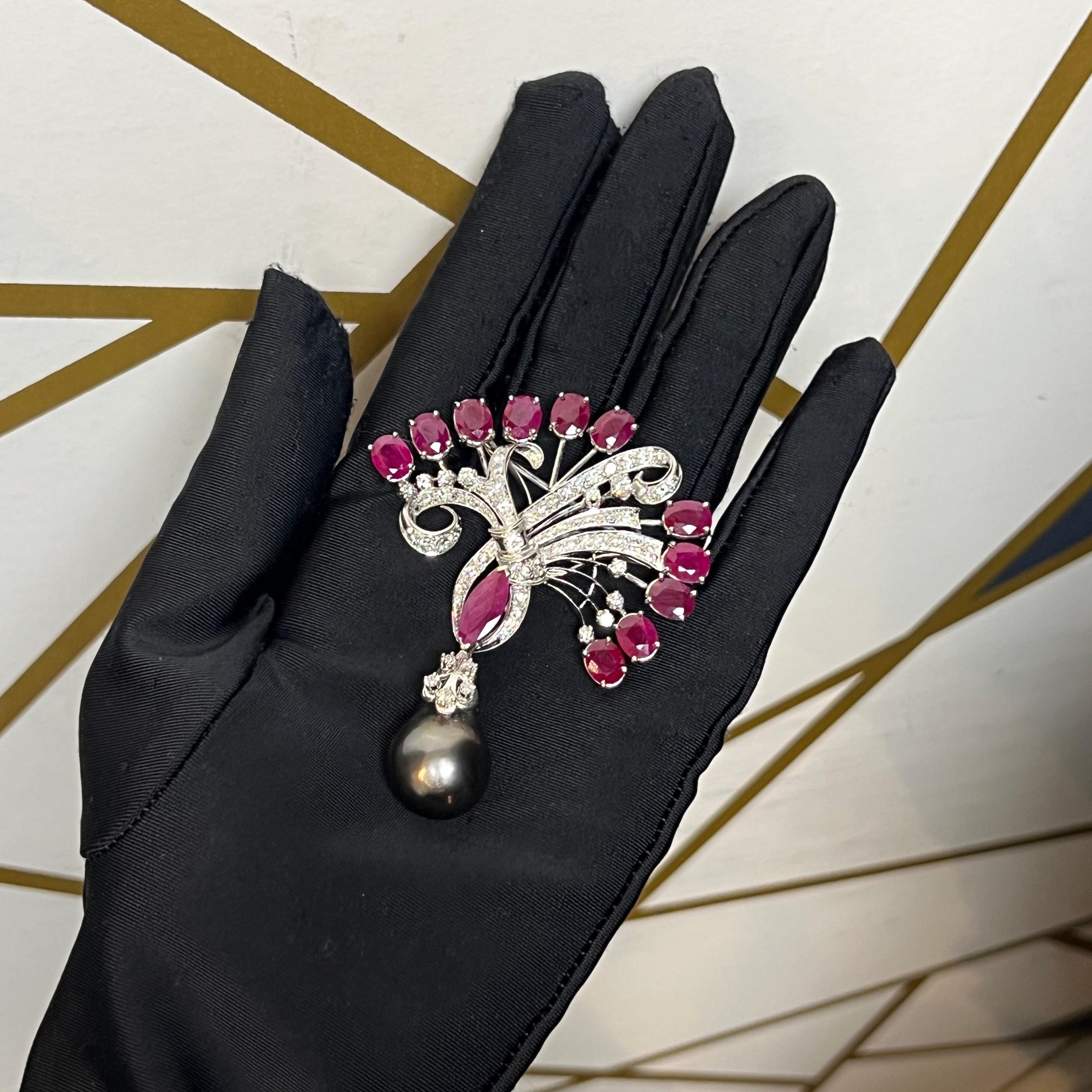 Spilla di rubino, perle e diamanti

 Una spilla con rubini taglio ovale, un rubino taglio marquise e diamanti tondi, che sospende una perla grigia.

Misure: Lunghezza 2,5 

Peso del rubino: 4,20 carati 

Peso del diamante: circa 3.84 carati 

Tipo