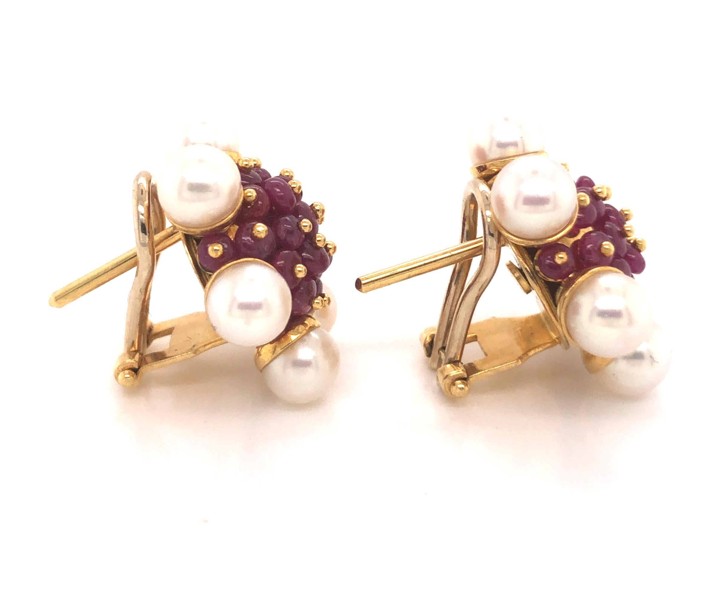 Beautiful pair of earrings crafted in 18k yellow gold.  This cluster design of earrings is truly fantastic. Pearls decorate the outside of the design as bead seat rubies highlight the inside of the earring. The rubies are set with gold tips giving