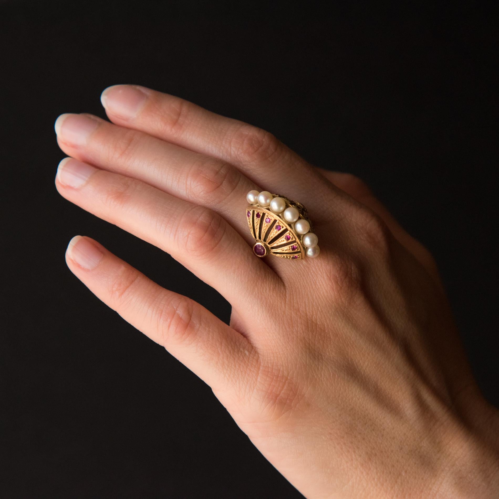 18K Yellow gold ring.
The design of this splendid ‘domed’ ring will fascinate you. It is decorated with 7 oriental cultured white pearls set in an openwork fan of rubies. 2 single rubies have been set on the shoulders of the ring.  
Our opinion: An