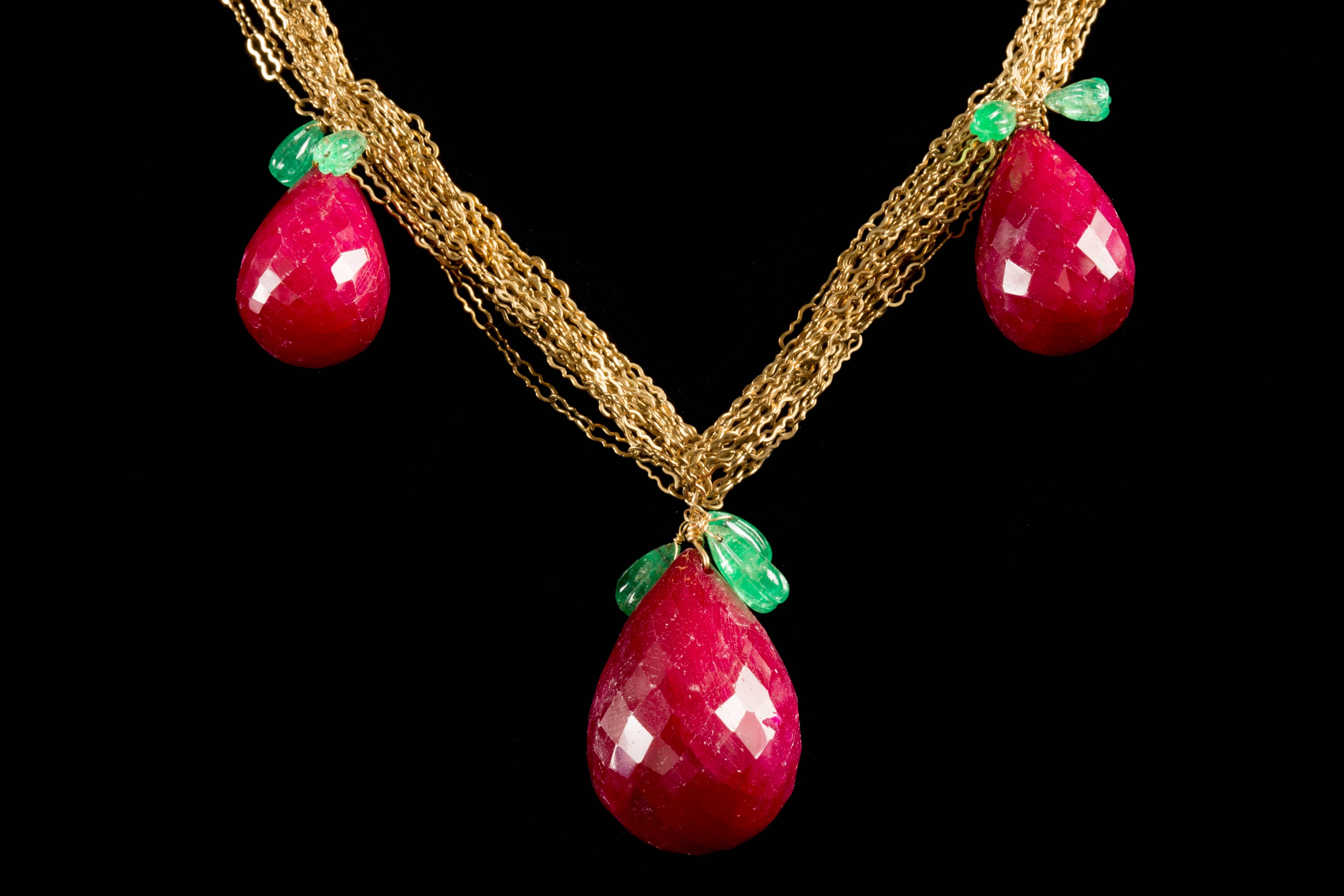 Beautiful Ruby Pear Necklace comprised of 3 briolette rubies, each with emerald leaves interlocked with a gold chain.