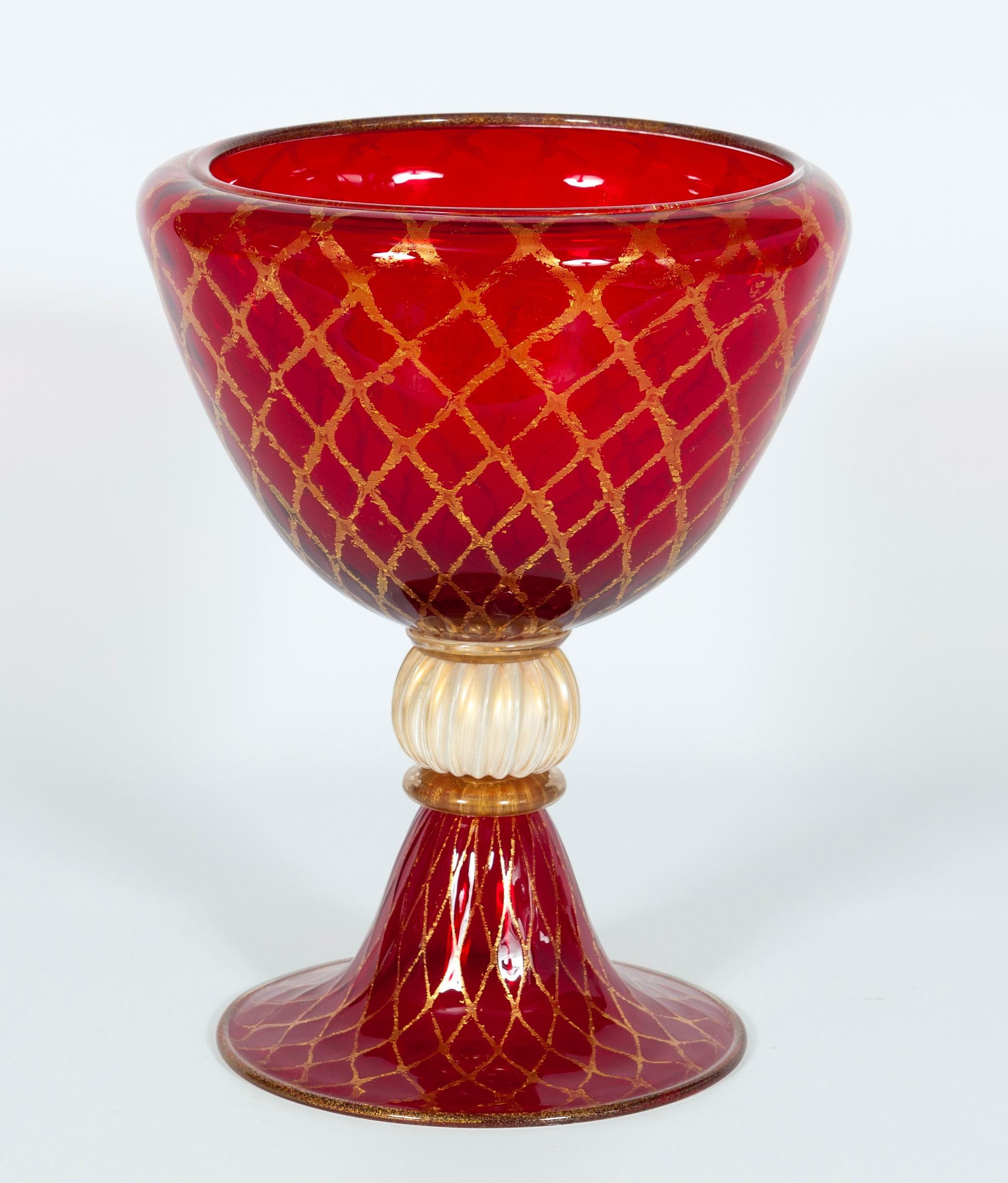 Ruby red bowl with 24-carat gold finishes in blown Murano glass, 1990s, Italy
This beautiful bowl is made with colorful ruby-red glass and gold rhombus patterns. The peculiar technique utilized to create the gold patterns is called (oro rotto)