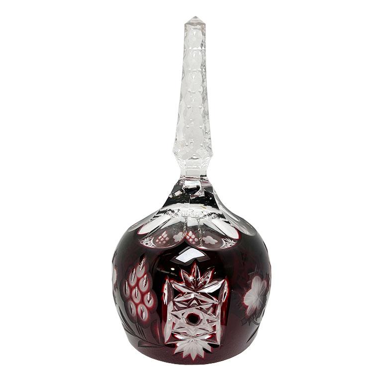 A pretty ruby red cut to clear crystal dinner bell. This will be a fabulous piece to use to call for those holiday dinners. It has a geometric carved transparent handle, which widens toward the bottom. The exterior of the bell is red, and etched and