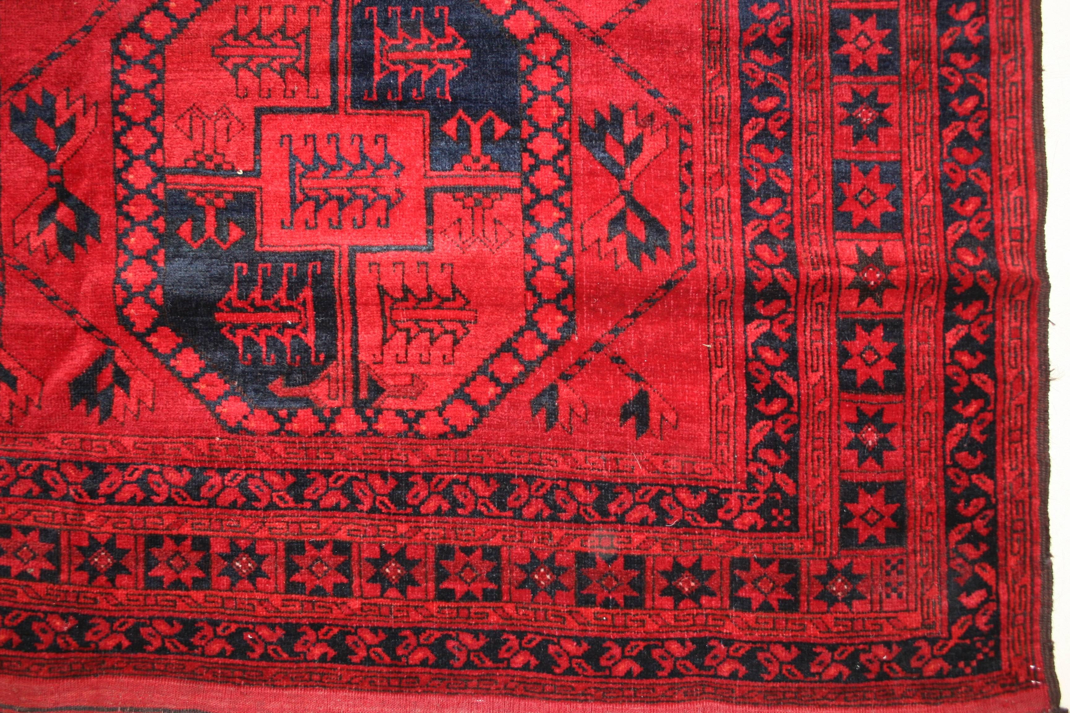 Un tapis principal turkmène classique qui se distingue par une tonalité unique de rouge rubis pour le fond. Le motif allover composé de trois rangées parallèles de dispositifs octogonaux est un élément caractéristique de la tribu turkmène des