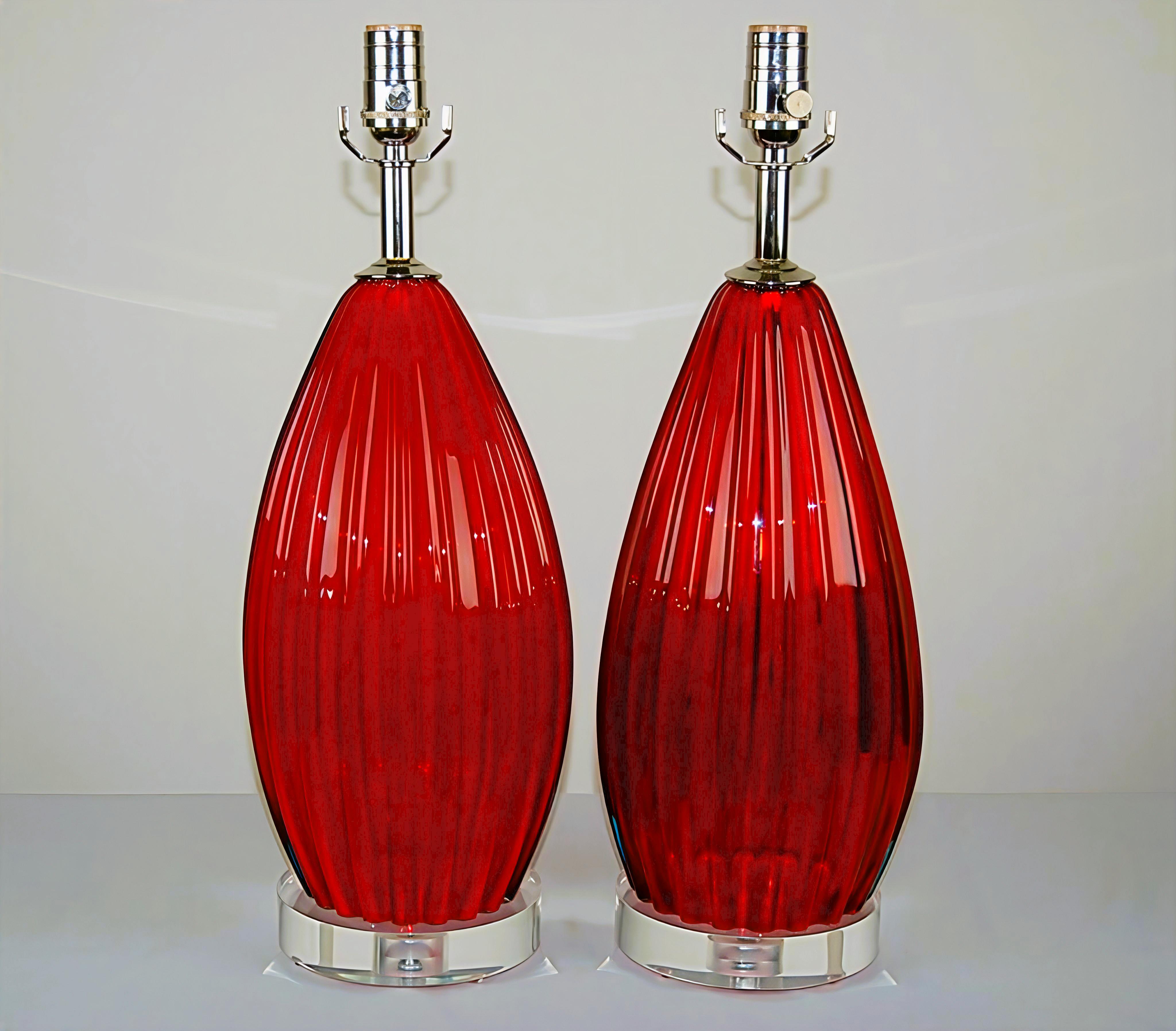 Queste lampade vintage di Murano di colore ROSSO RUBINO sono state soffiate negli anni Cinquanta. Quando il sole colpisce i vetri, fai attenzione: è come se prendessero fuoco! Le costole fanno rimbalzare la luce in modo meraviglioso. 

Le lampade si