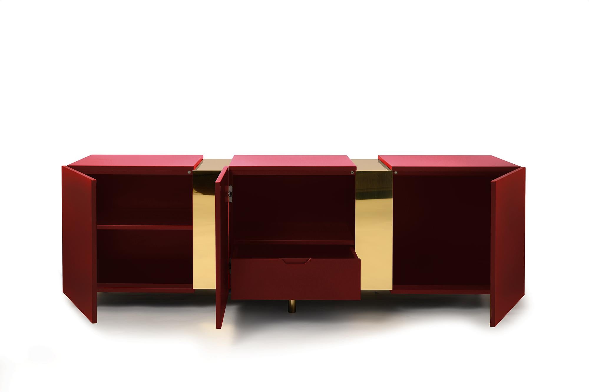 Eunduetrè is a low storage system which punctuates the space and plays with contrasting effects. Extremely simple in its geometric shapes, this sideboard/credenza alternates colorful cubes in matte lacquered wood, with sections of bent brass sheet