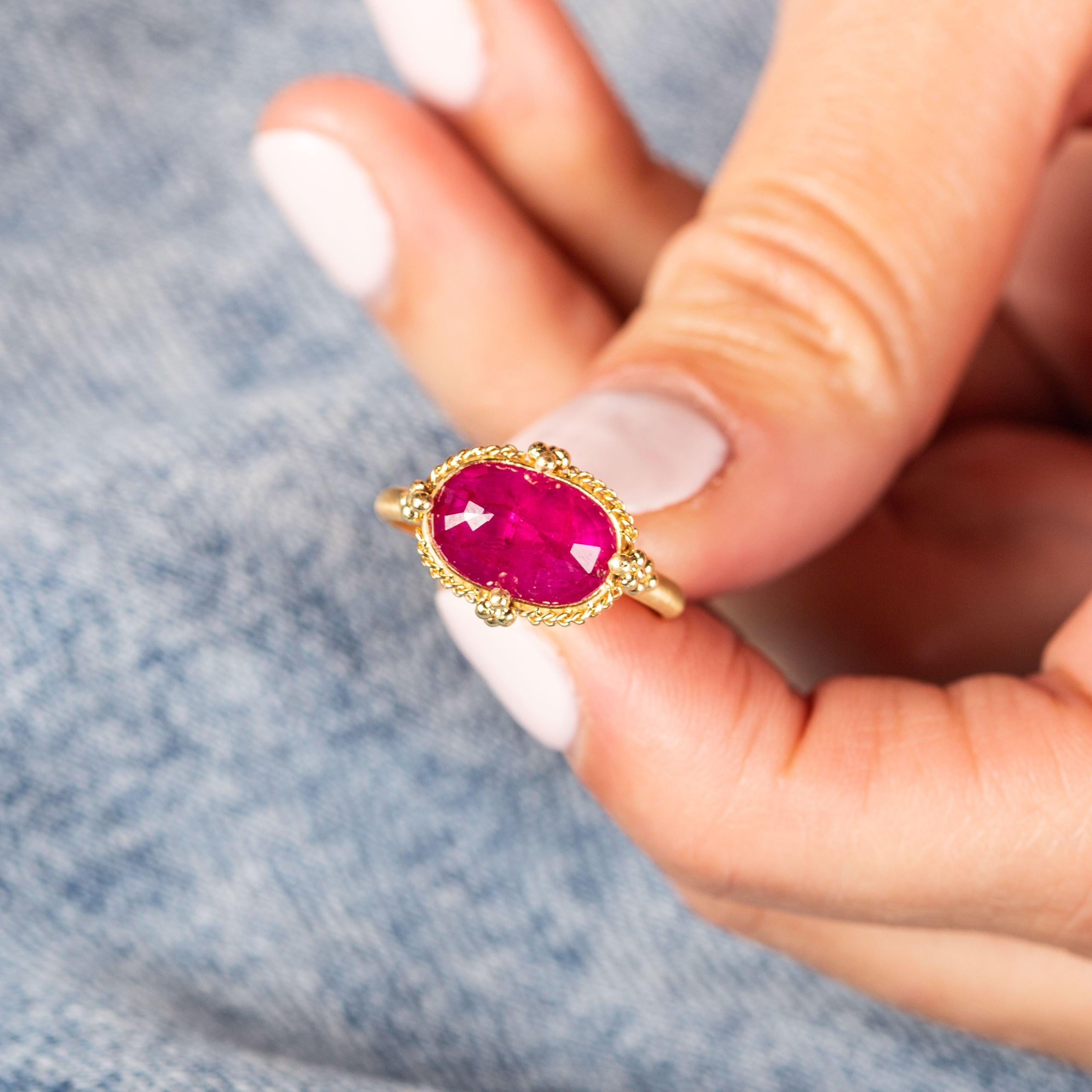 This Ruby ring warms and energizes with flashes of bold, crimson hues floating beneath the surface like flowing lava. To accentuate the natural beauty of this gemstone, we encased it in an intricate frame of golden chain and delicate beaded prongs.