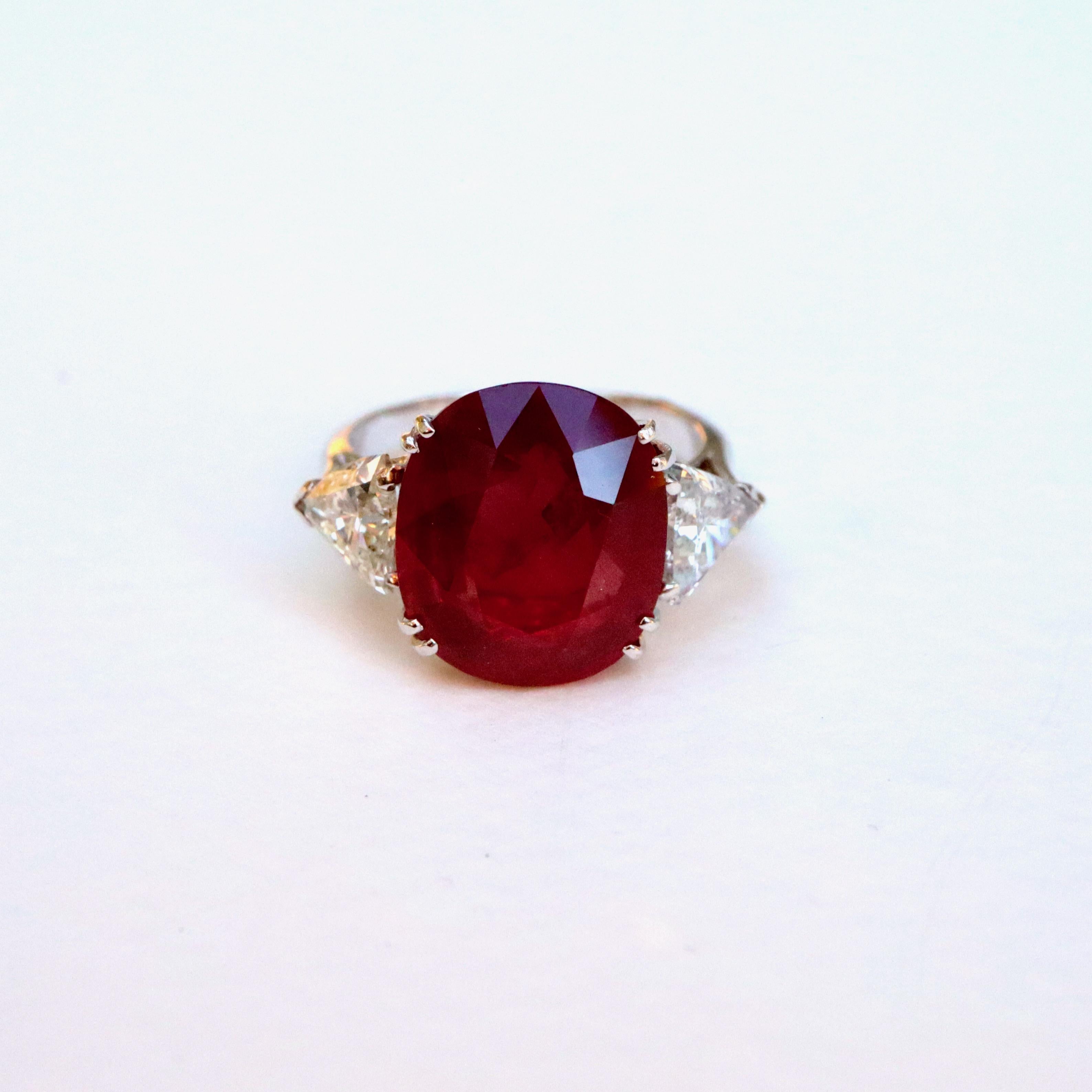 18 karat white gold ring setting a large 11.4 carat ruby in its center, supported on either side by a large triangle diamond of 0.70 carat each, for a total weight of 1.4 carats. 
Ruby length: 14 mm width: 12 thickness: 23 mm 
Two diamond triangles