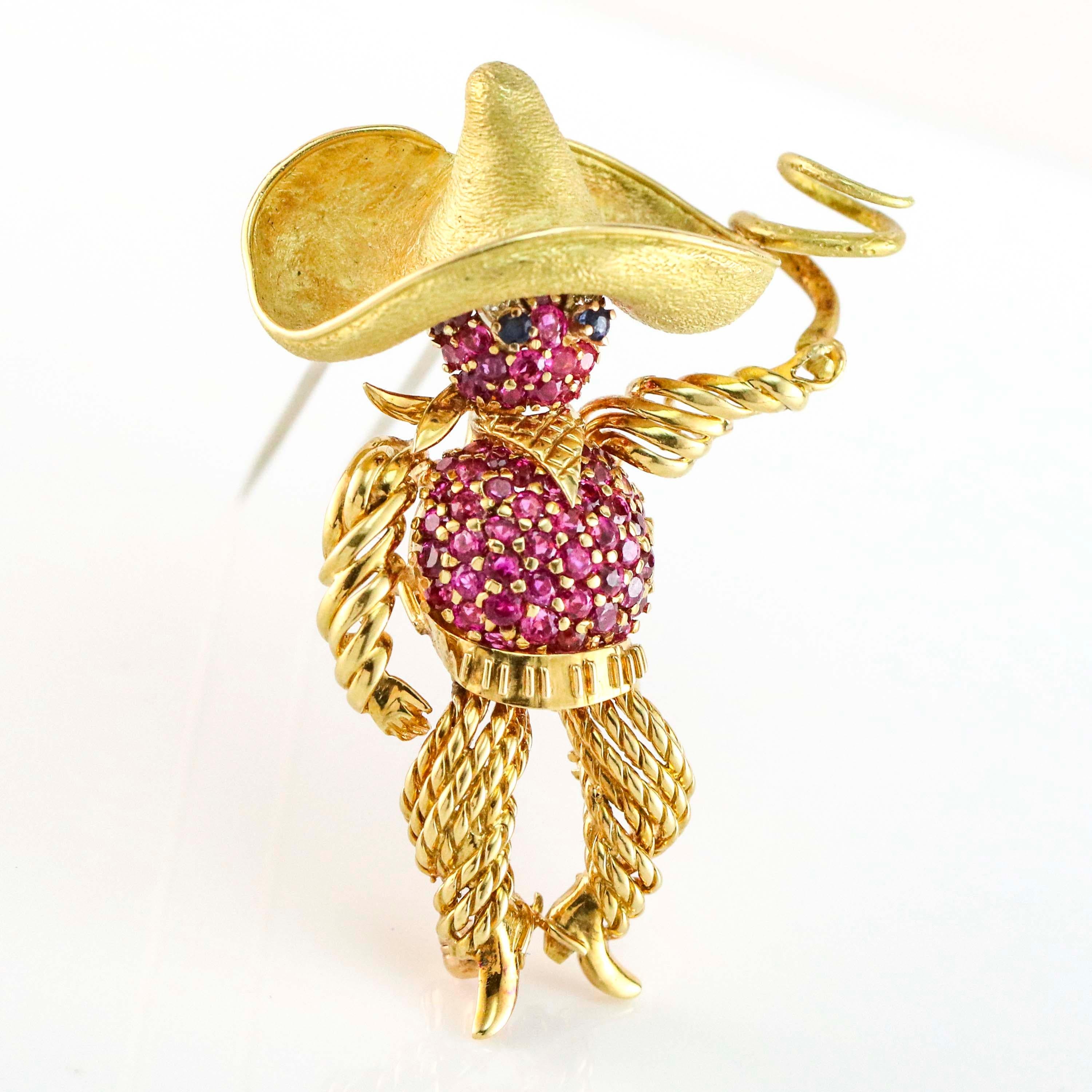 Cowboy with a sombrero and lasso pin in 18 karat yellow gold. The brooch is pave set with rubies, diamonds and sapphires.