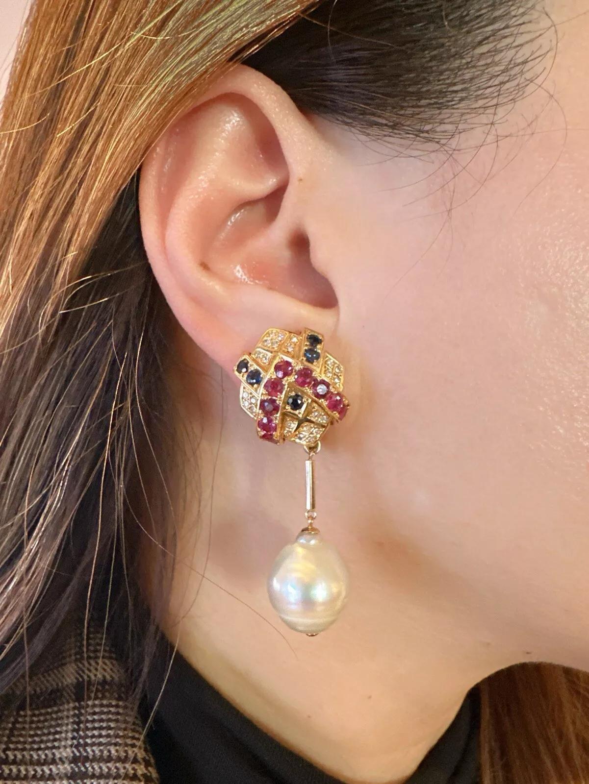 Ruby, Sapphire, Diamond & Pearl Drop Earrings in 18k Yellow Gold 

Pearl and Gemstone Drop Earrings features Round Red Rubies, Blue Sapphires, and Brilliant Diamonds set in a geometric pattern with a dangling pear, all set in 18k Yellow Gold. The