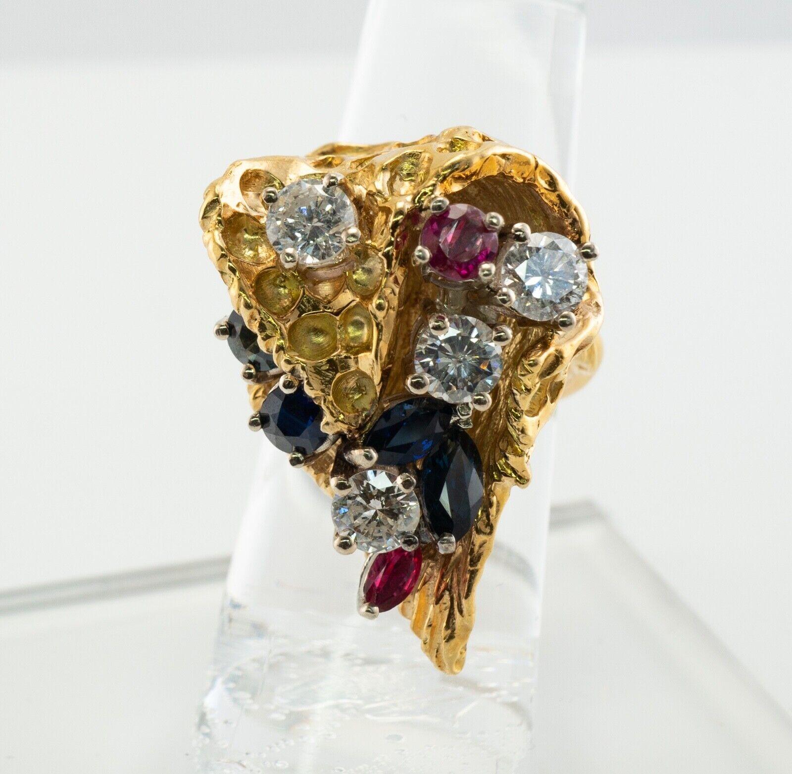 This gorgeous one of a kind vintage ring is crafted in solid 18K Yellow Gold. The textured highly detailed bucket setting holds four natural Diamonds, Ruby, and Sapphires. Three diamonds are .50 carat each, one gem is .40 carat. The grand total for