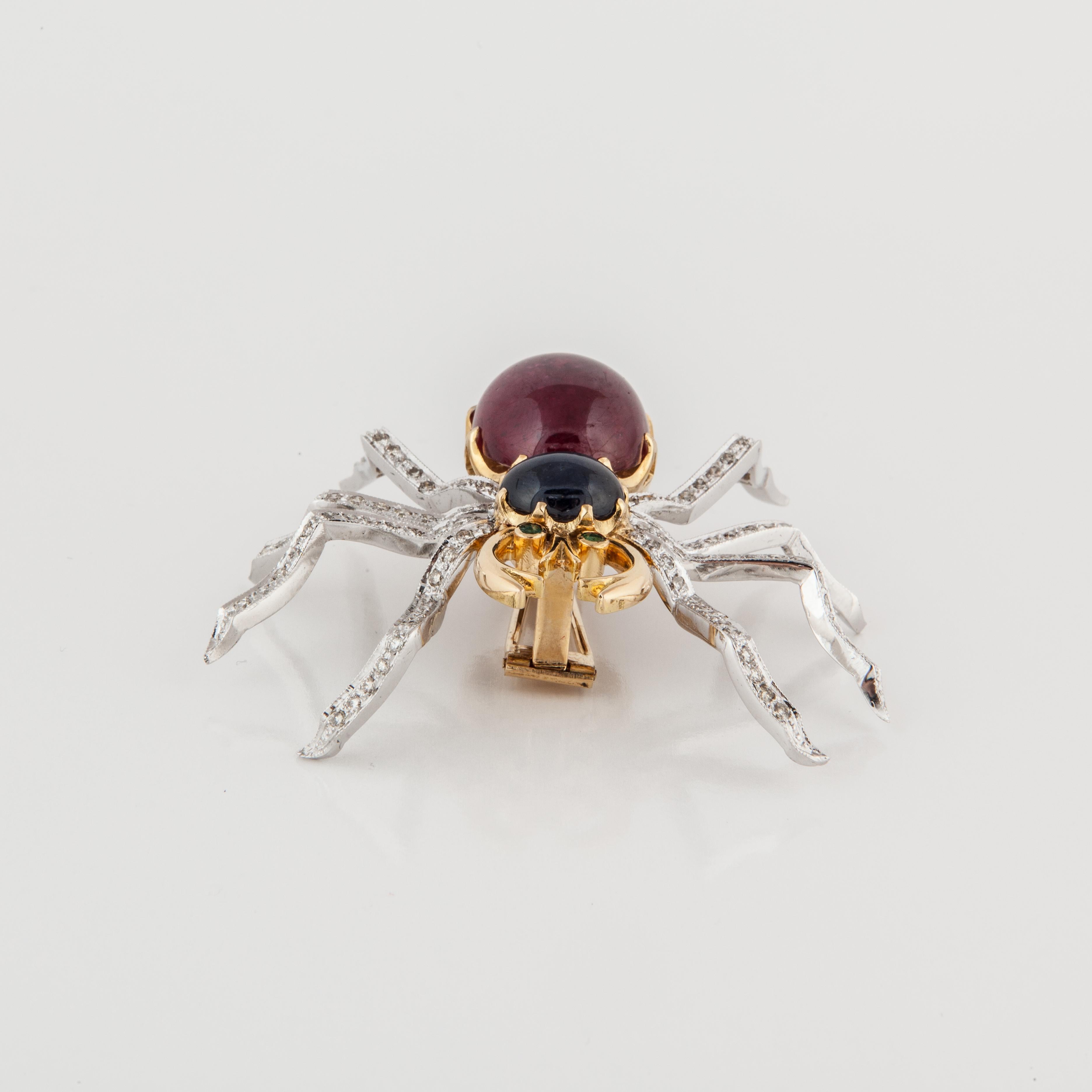 Gemstone and diamond brooch composed of 14K yellow gold.  The body is a 27.80 carat cabochon ruby and a 5.50 carat cabochon sapphire.  The eyes are round emeralds.  There are a total of 3.35 carats of diamonds in the legs, L-P color and VS1-VS2