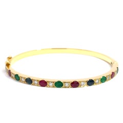 Armreif mit Rubin, Saphir und Smaragd aus 18k Gelbgold mit Diamantbesatz - 19,40g