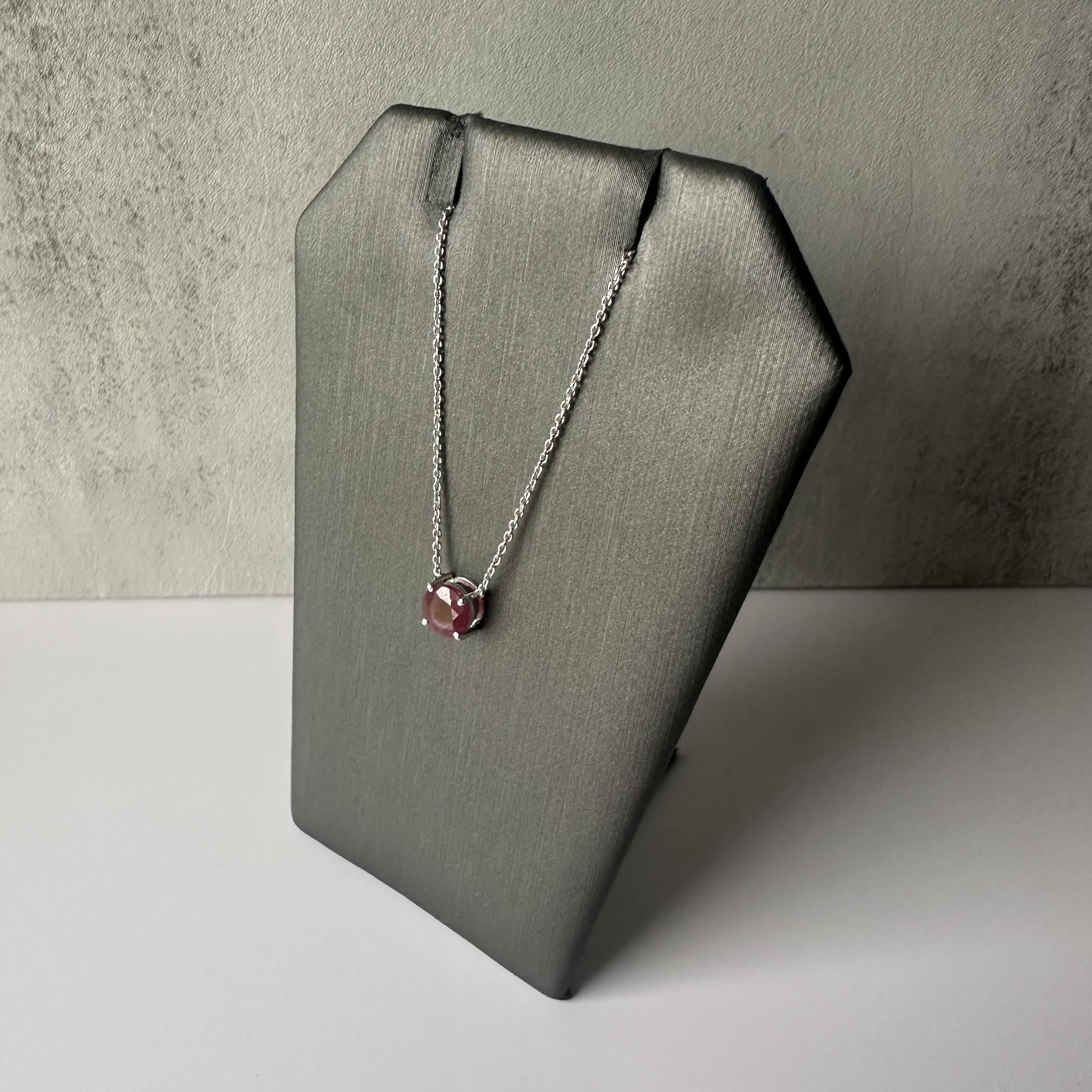 Enhance your jewelry collection with this exquisite Ruby Pendant Necklace in 14k White Gold. Featuring a captivating 0.9 carat round ruby, this necklace showcases a vibrant red hue that draws the eye. The ruby is elegantly set in a minimalist